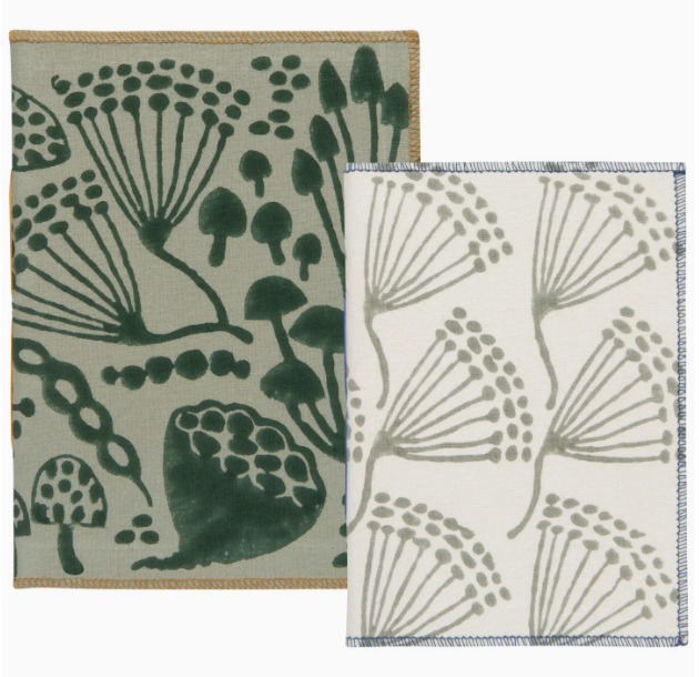 Two small notebooks featuring green and white designs, stacked side by side on a flat surface.