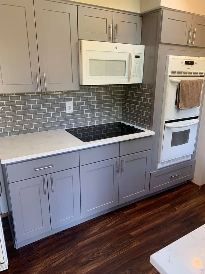 Modern kitchen remodel with gray cabinets, tile backsplash, and sleek white countertop in Everett, WA
