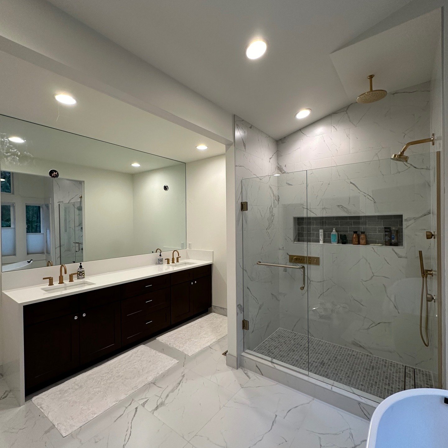 Contemporary bathroom remodel with marble tile, glass shower, and gold fixtures in Everett, WA