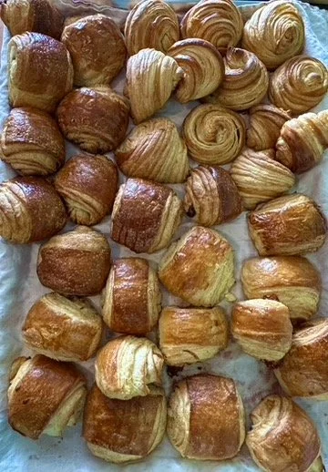 Assorted buttery croissants and pastries on a tray