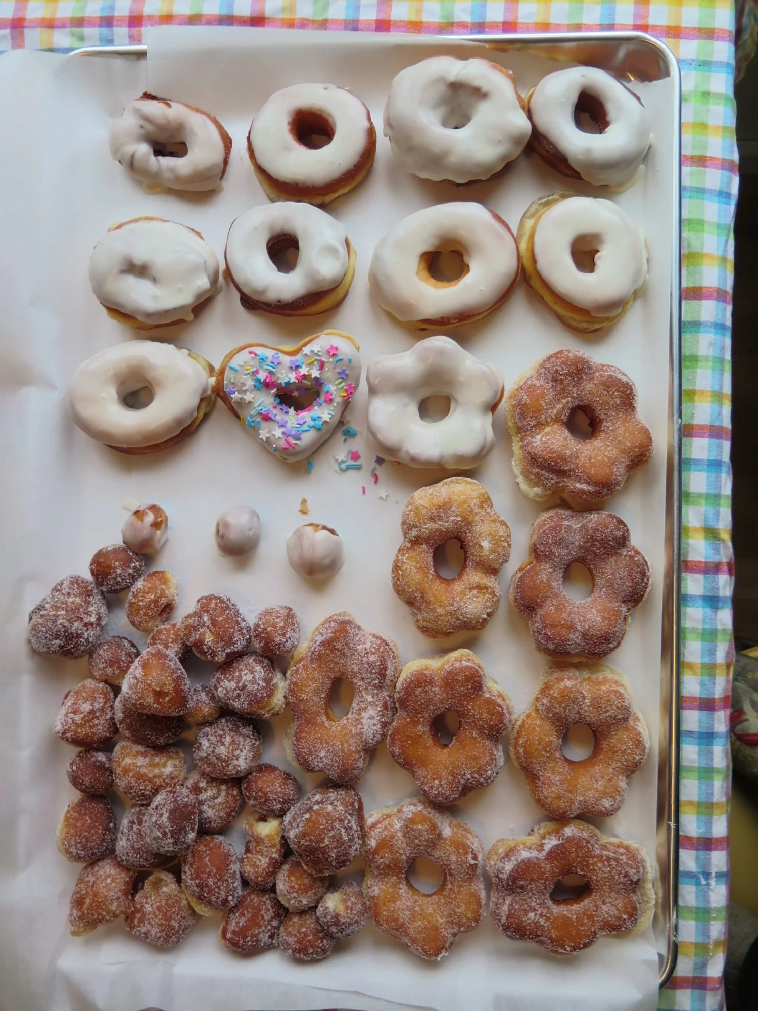Tray of assorted donuts and pastries with icing and sprinkles