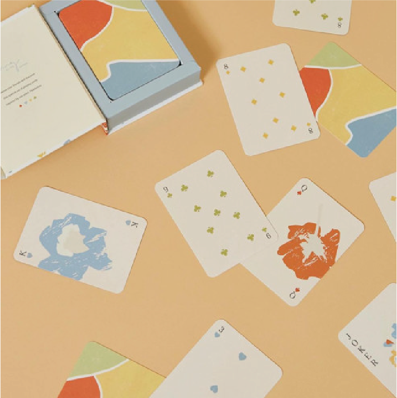 Playing cards from the game 'Skip-Bo' scattered on a table with a box open beside them.