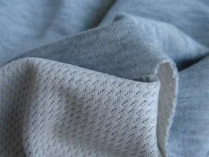 Close-up of fabric, showing both a soft, grey material and a white, textured lining.