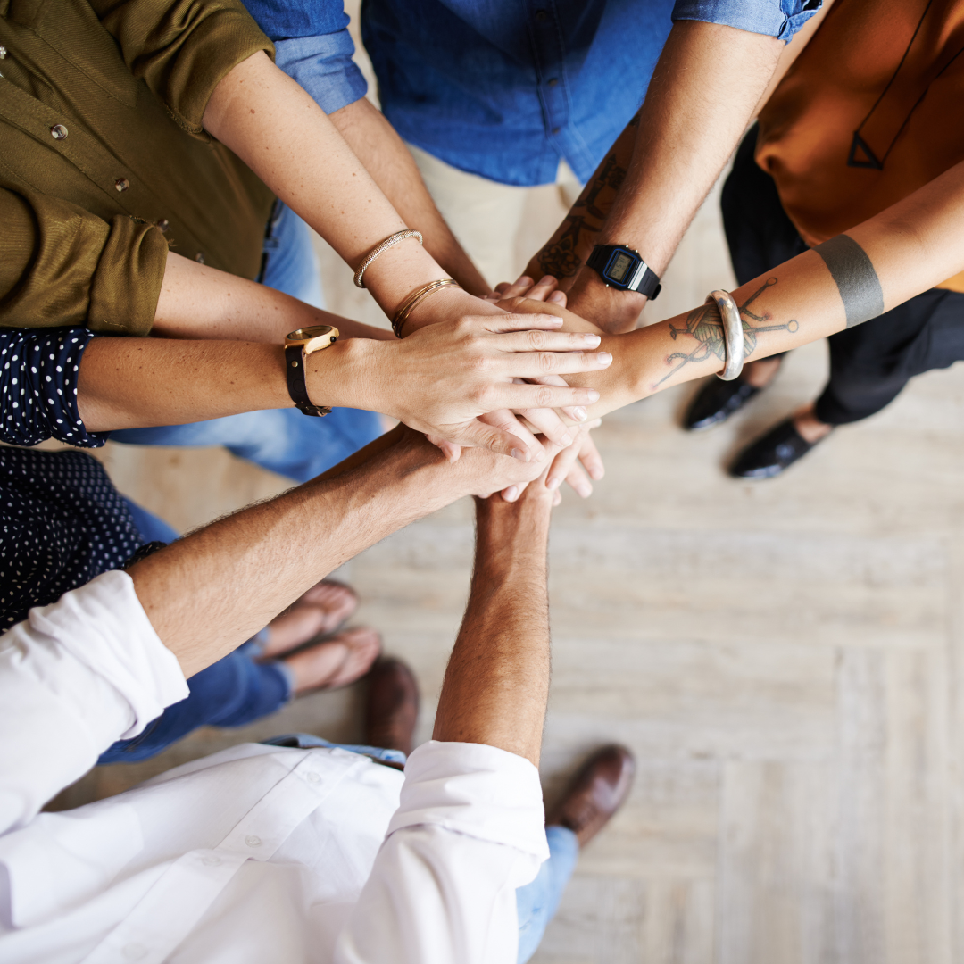Group of people piling their hands together in the middle