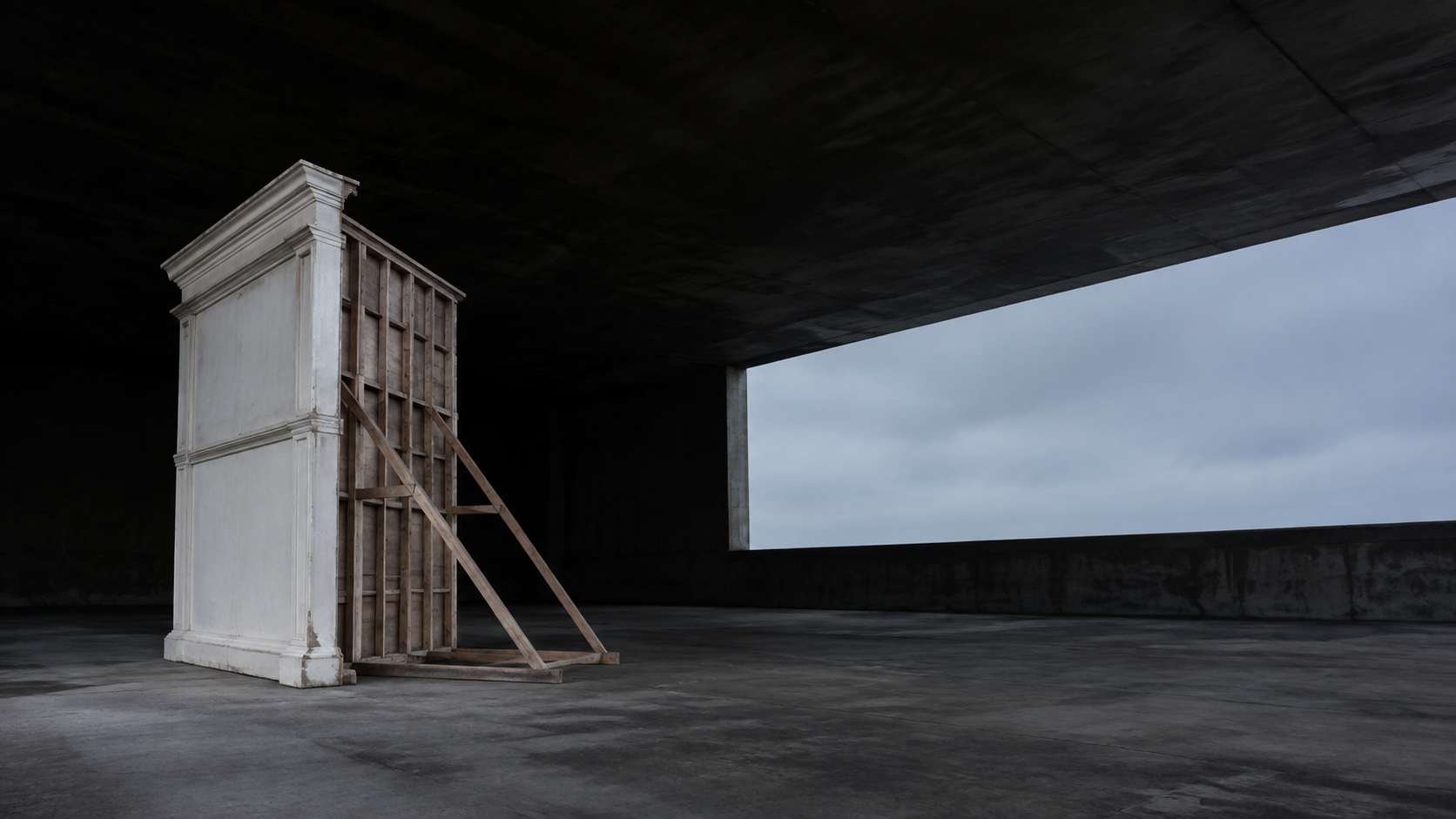 The unfinished back and timber braces of a freestanding facade reveal what supports its clean white front.