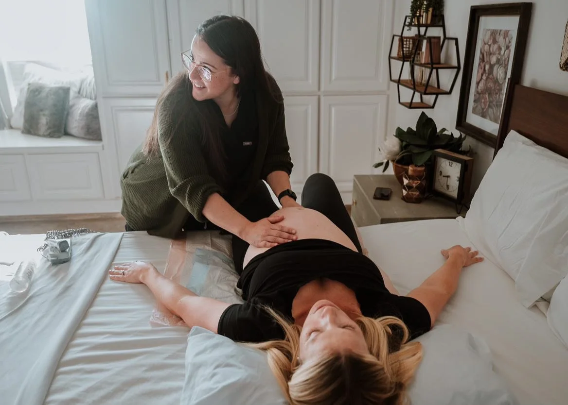 Midwife offering gentle, hands-on leopold's to determine position of baby on a pregnant client during a prentalt visit in one of our peaceful birth suite at our midwife-led Texas birth center.
