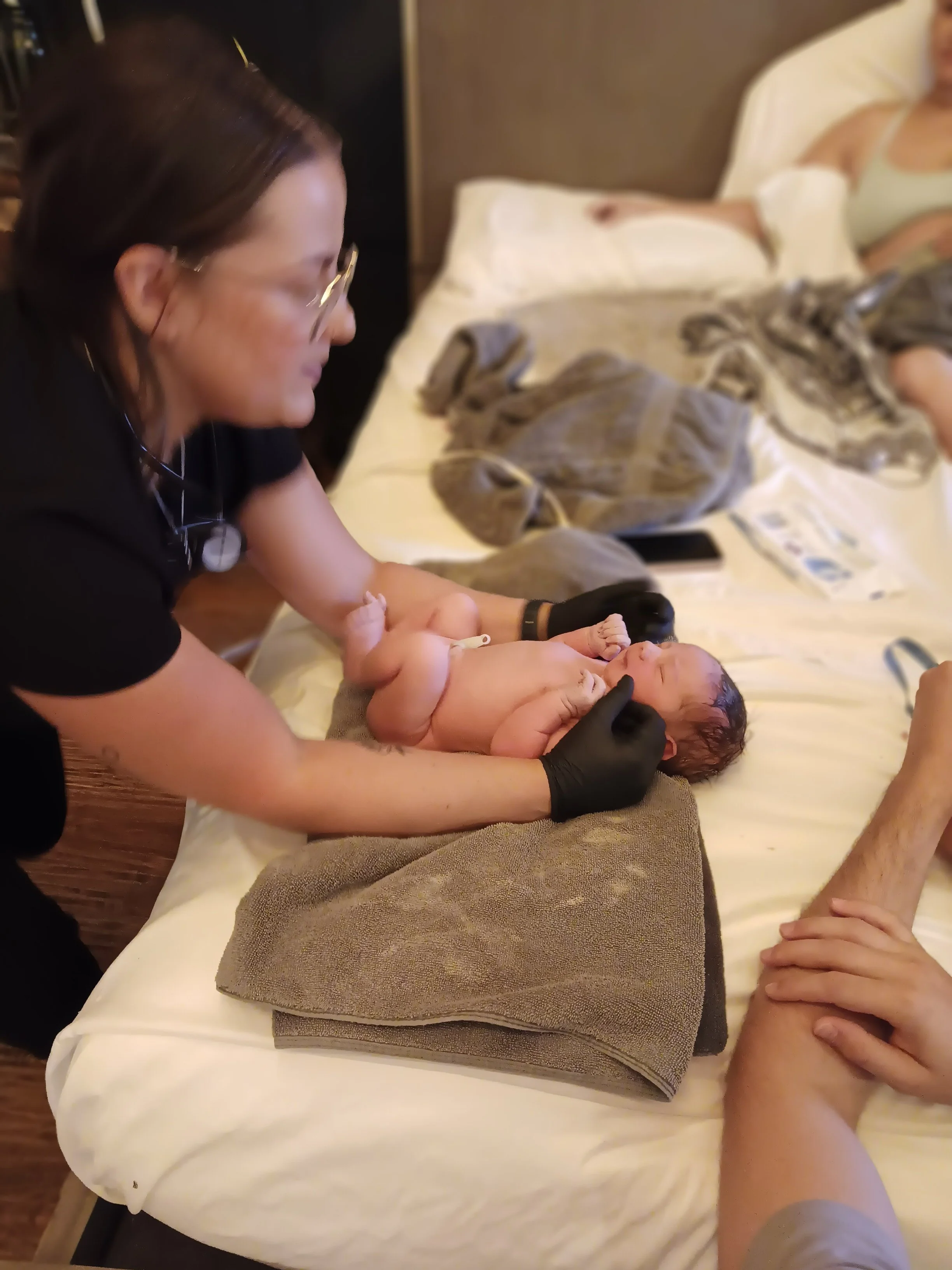 midwife ashton performing newborn exam on baby born at our Texas birth center