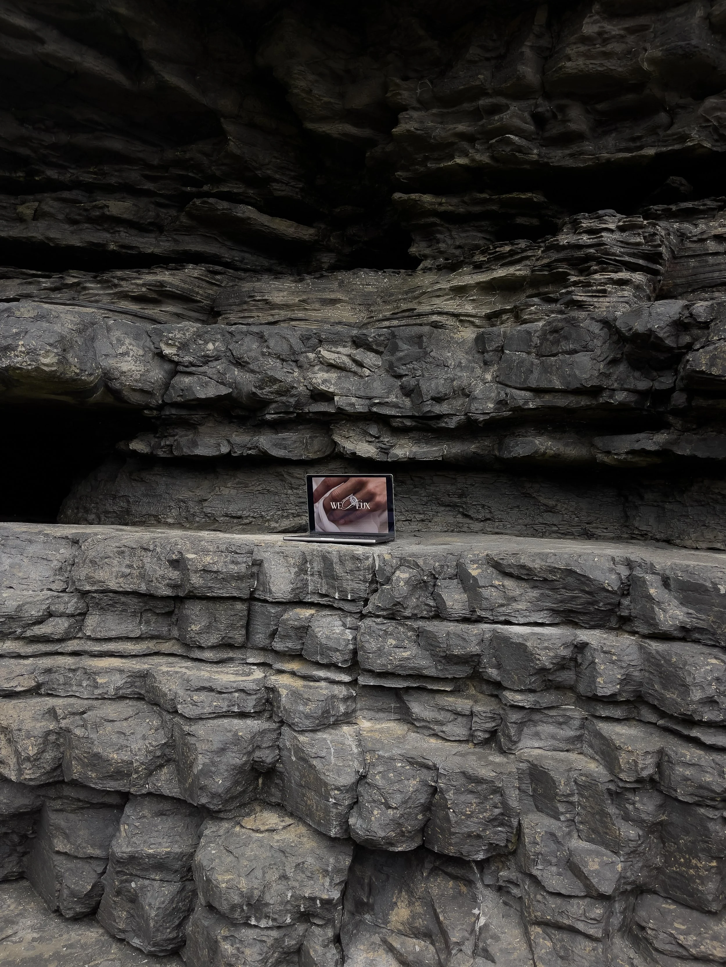 brand photograph go a laptop on a rock with brand logo image displayed