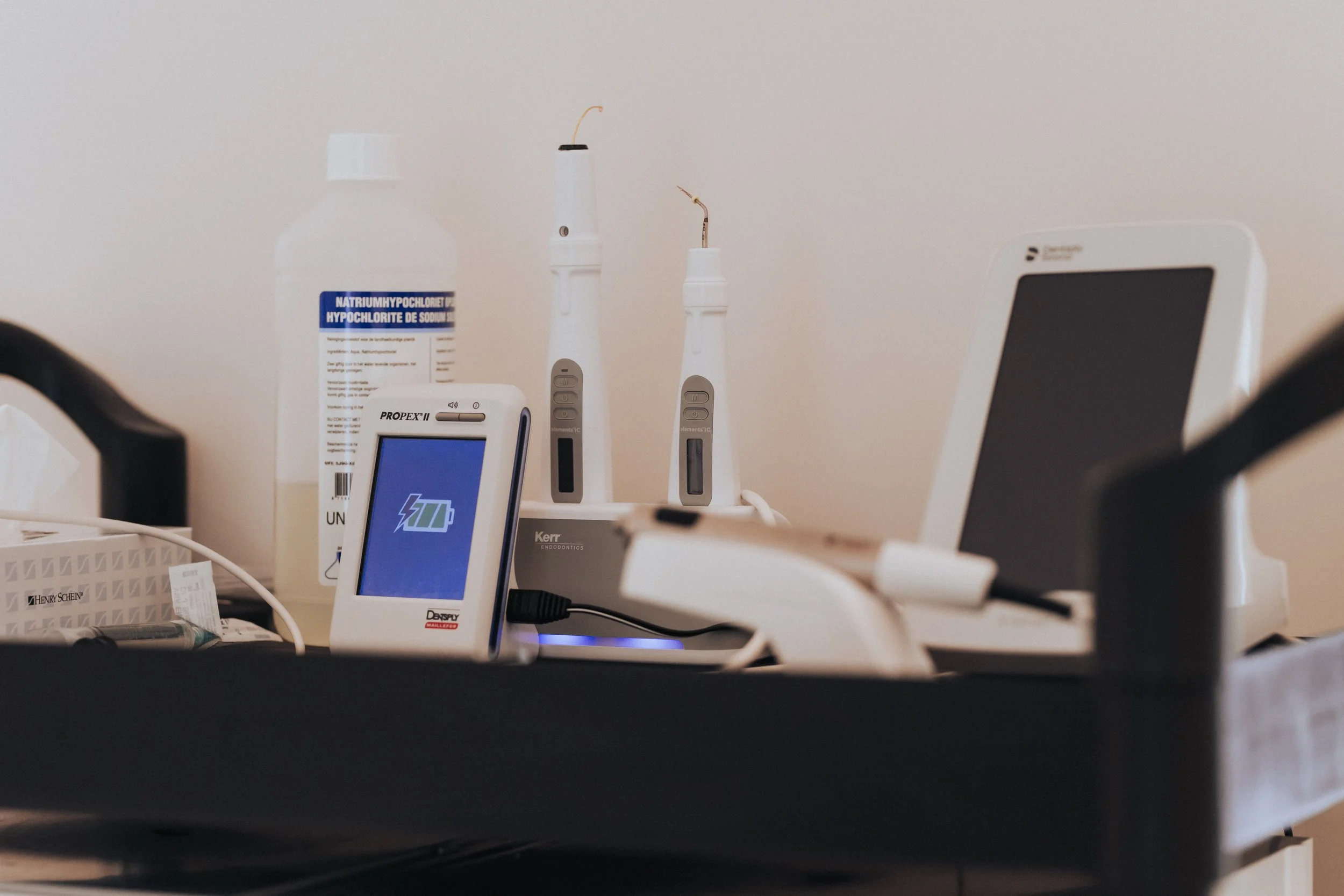 Medical tools and devices including a blood pressure monitor, dental instruments, and a digital device on a hospital or clinic counter.