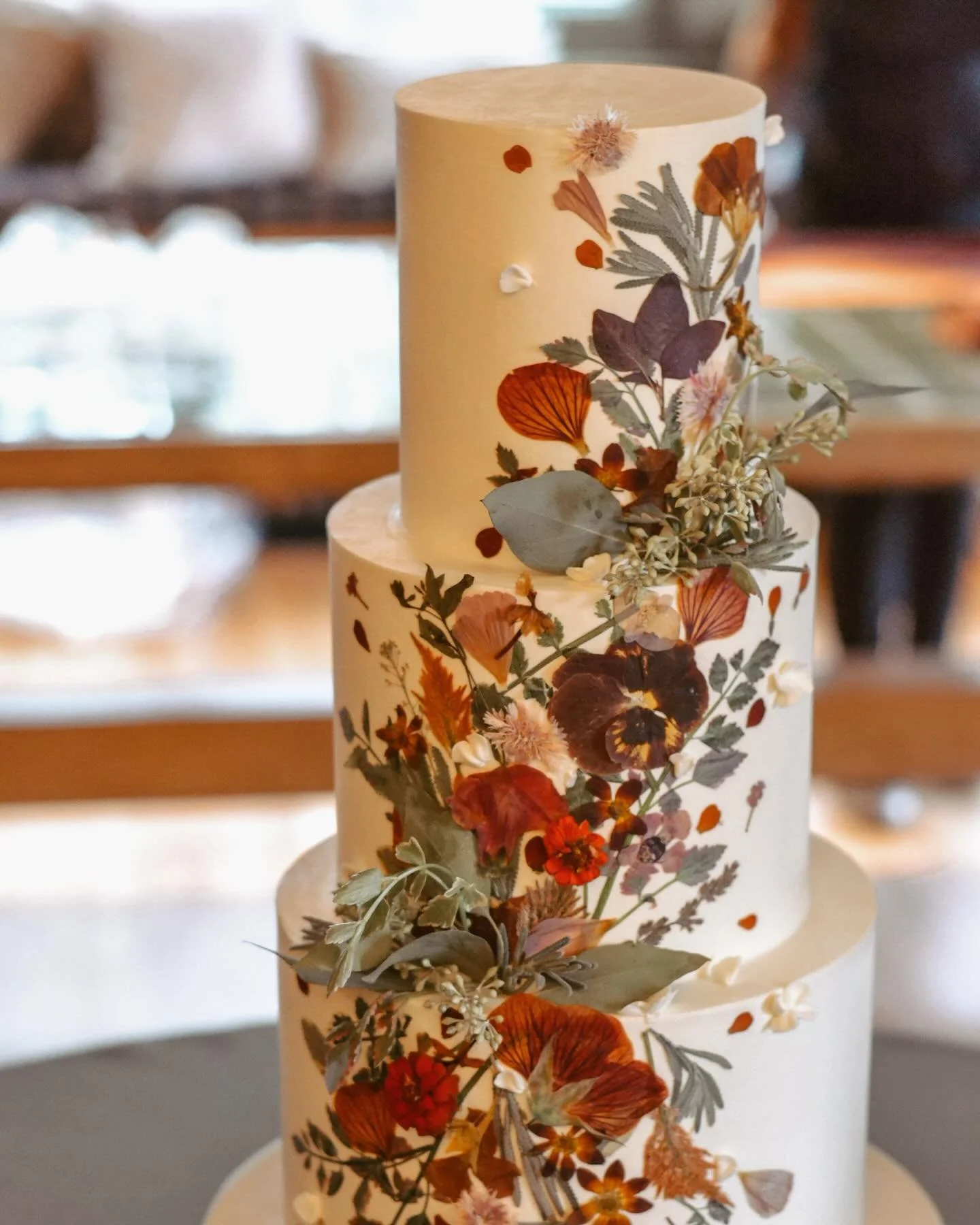A different take on the popular pressed floral cake. This is our fall version-mixing dried flowers in tones of oranges and purples with fresh greenery.