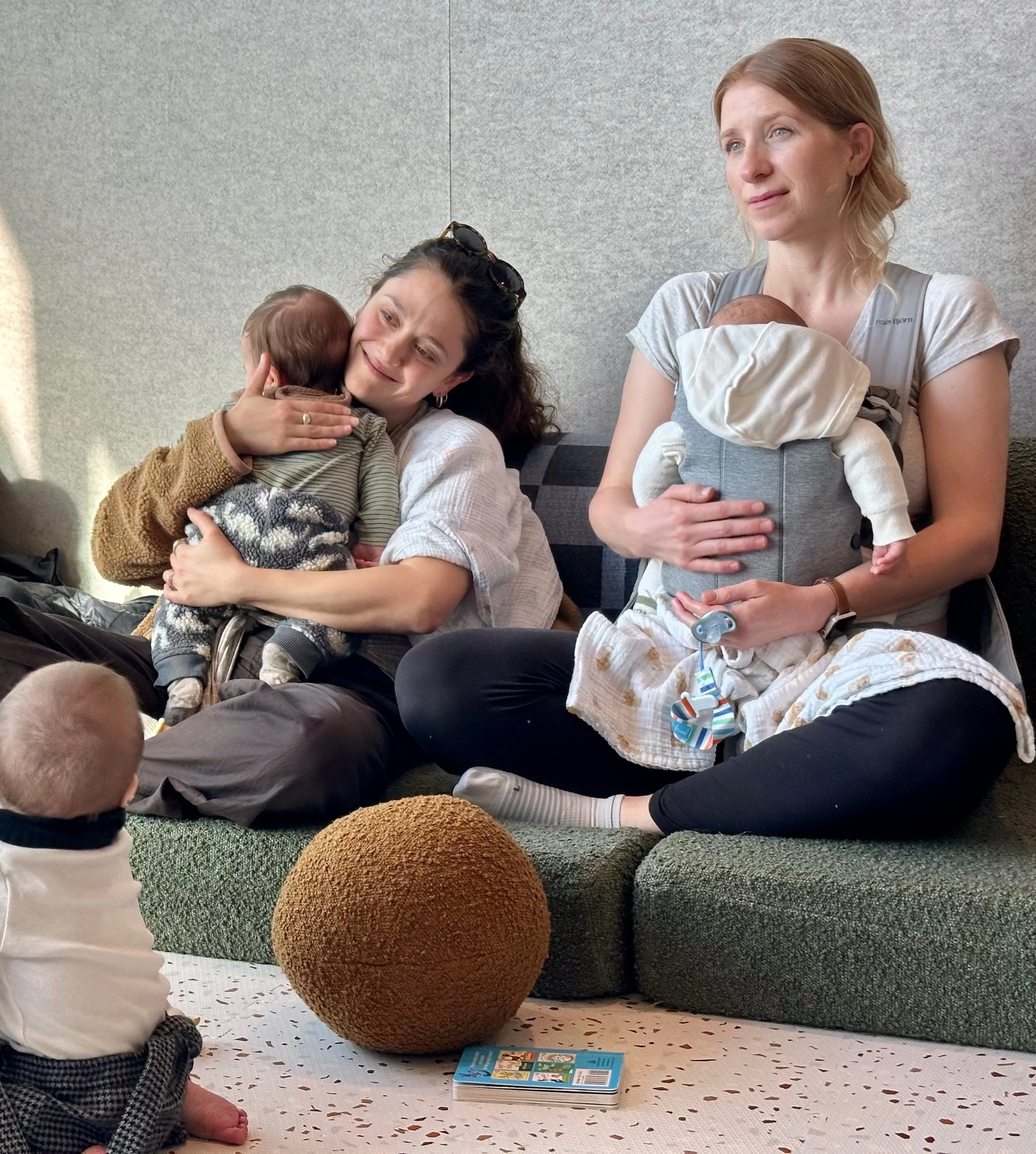 The silhouette of a pregnant woman lifting a child overhead, seen through a frosted glass window.