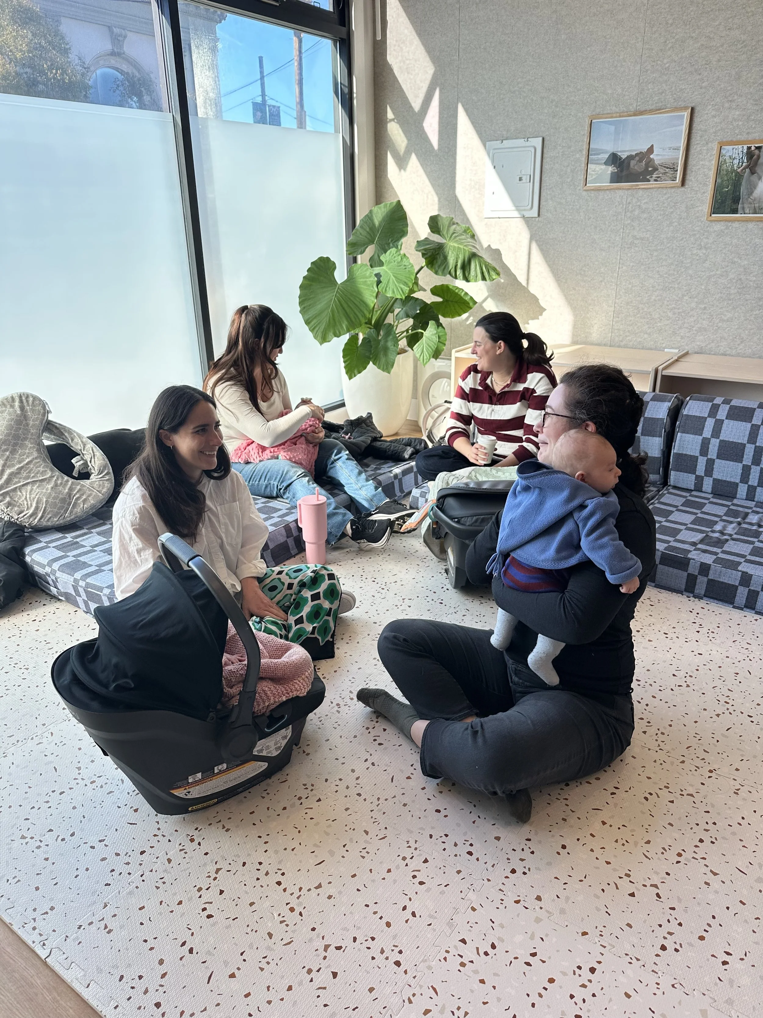 New moms and their babies playing and talking during a New Moms Group at Outer Village.
