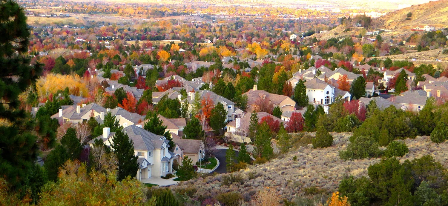 Juniper Trails Upland residential neighborhood with colorful fall foliage, houses, and trees in a hilly landscape