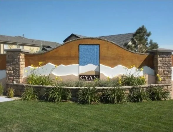 Cyan A decorative outdoor wall mural of a yellow butterfly with black antennae on a brown and white background, featuring the word 'CYAN' beneath the central blue section.