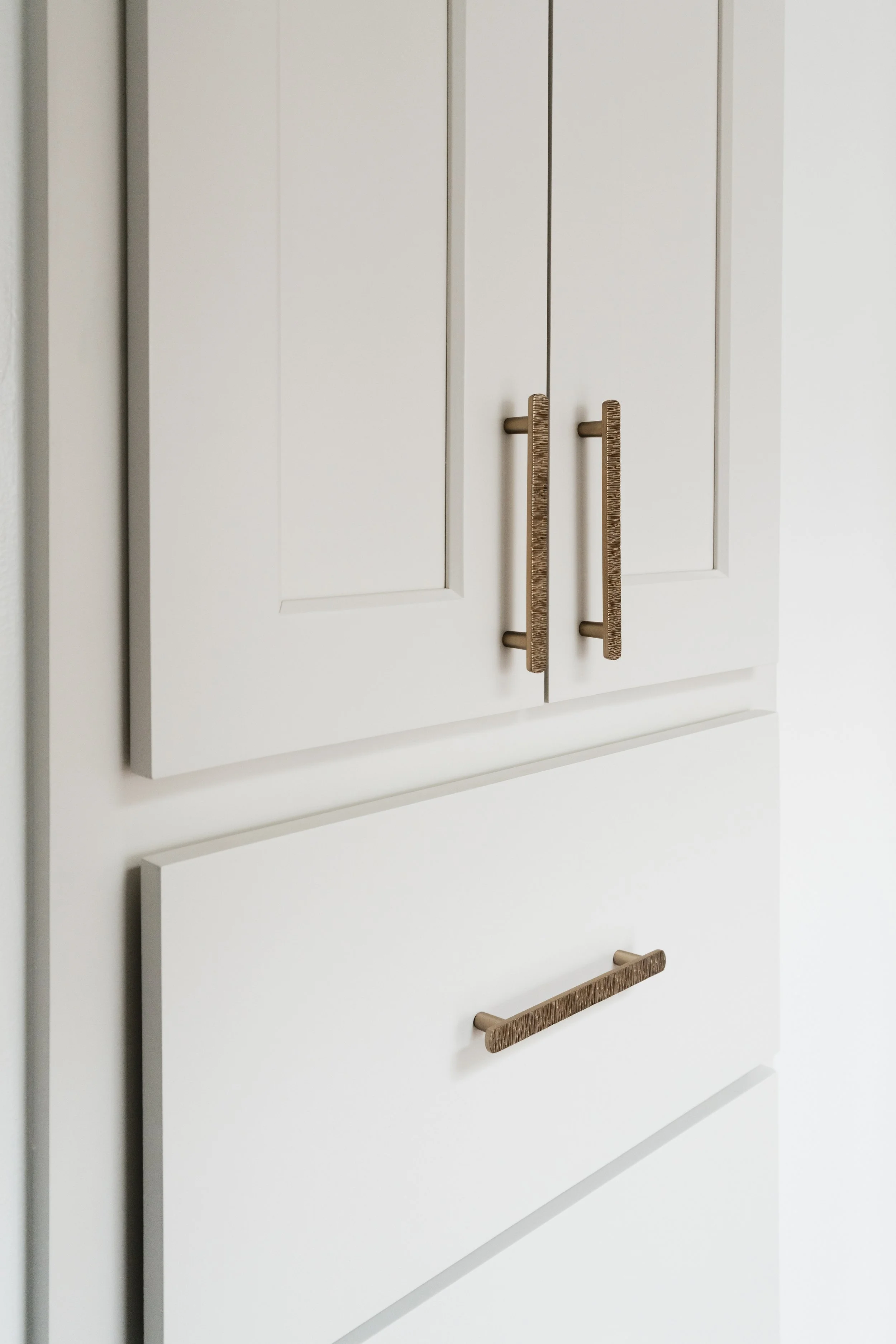 Close-up of refinished built in cabinet doors with modern gold handles.