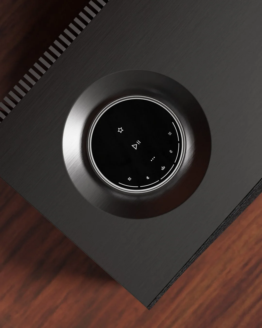 Close-up of a black, circular smart speaker or sound system control dial on a wooden surface, with touch controls visible.