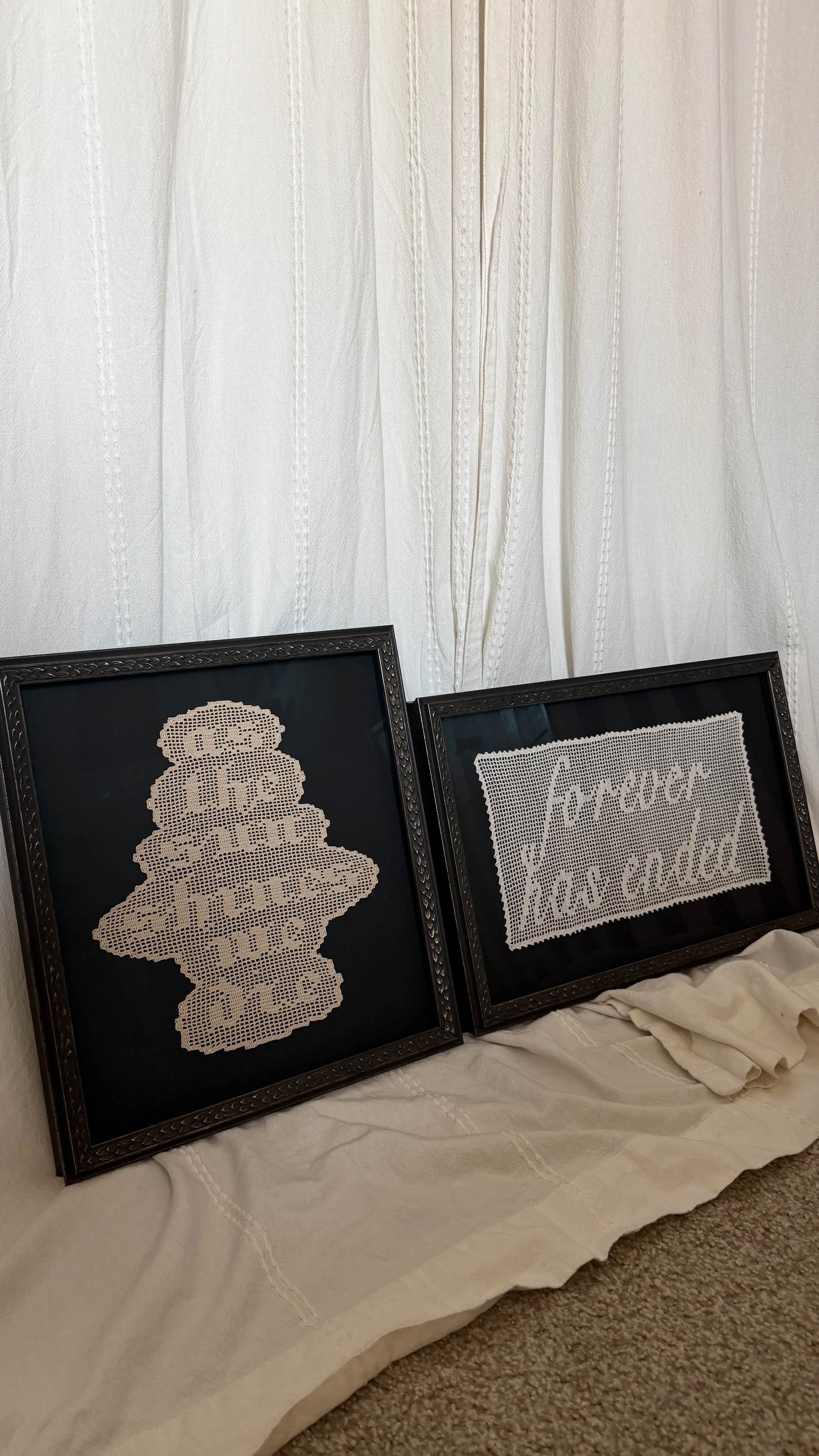 Two original filet crochet artworks that are framed, in front of a white background. First piece says, "as the sun shines we die". Second piece says, "forever has ended".