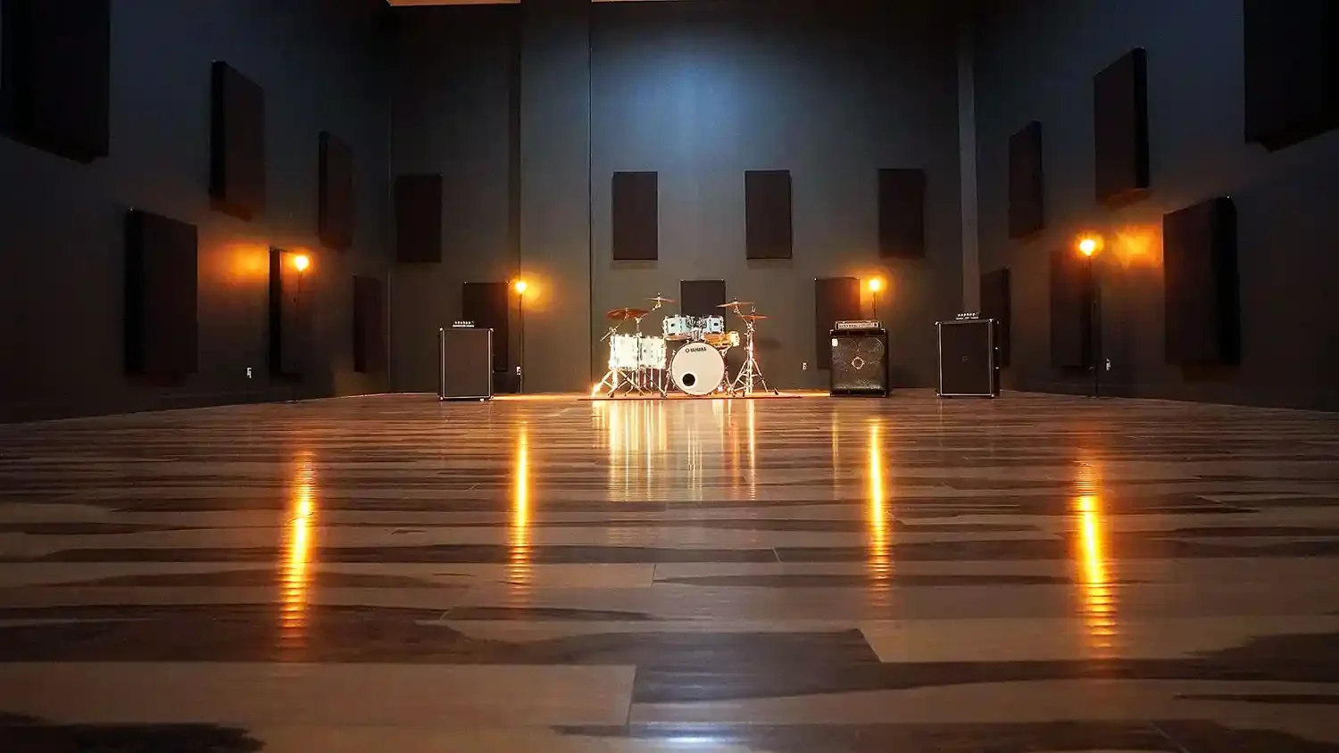 Grande salle de répétition avec batterie et amplificateurs