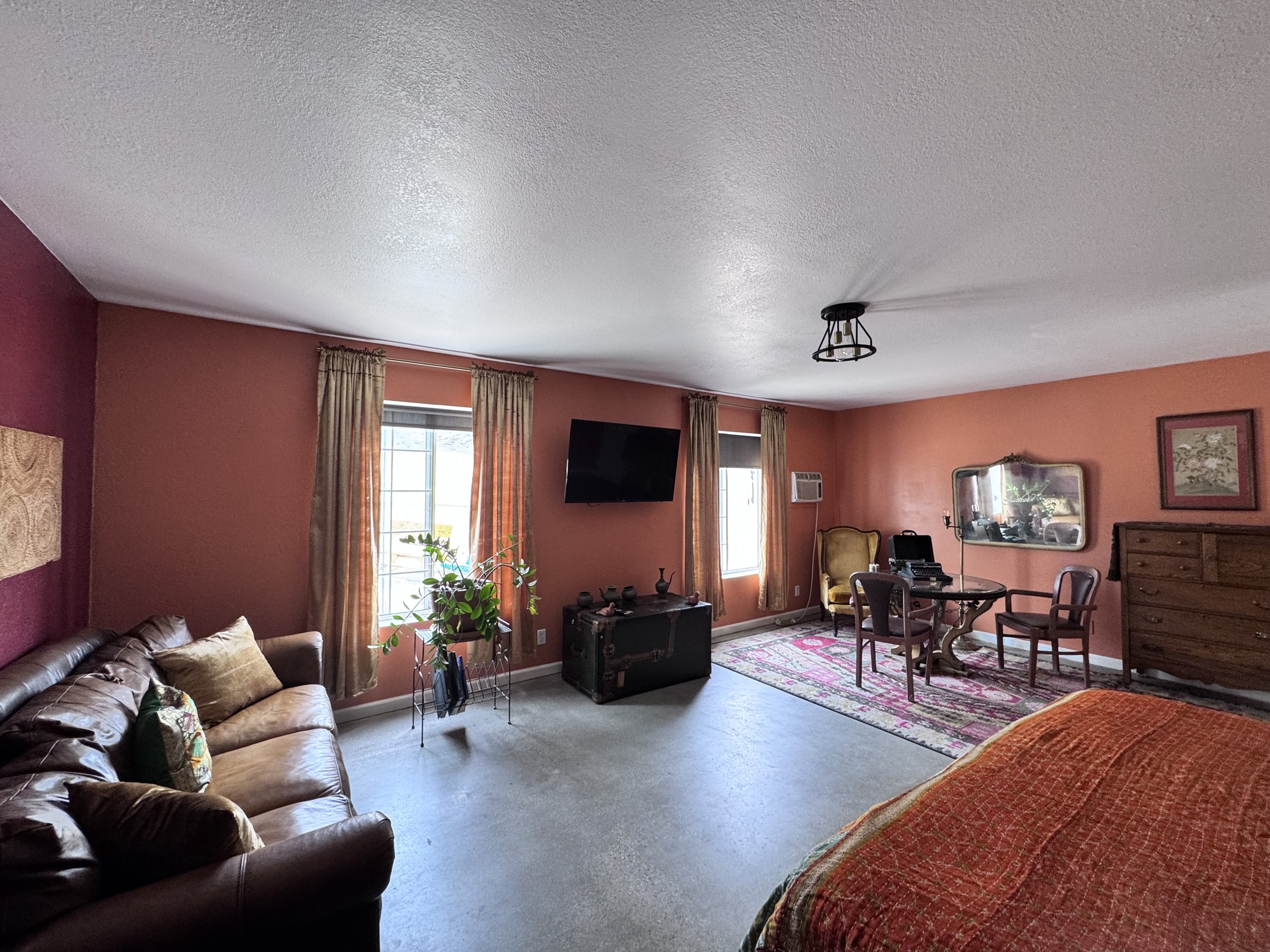 The Chambers room, with vintage leather sofa, large television, and dining seating area. The Chambers also has its own bath and attached kitchenette.