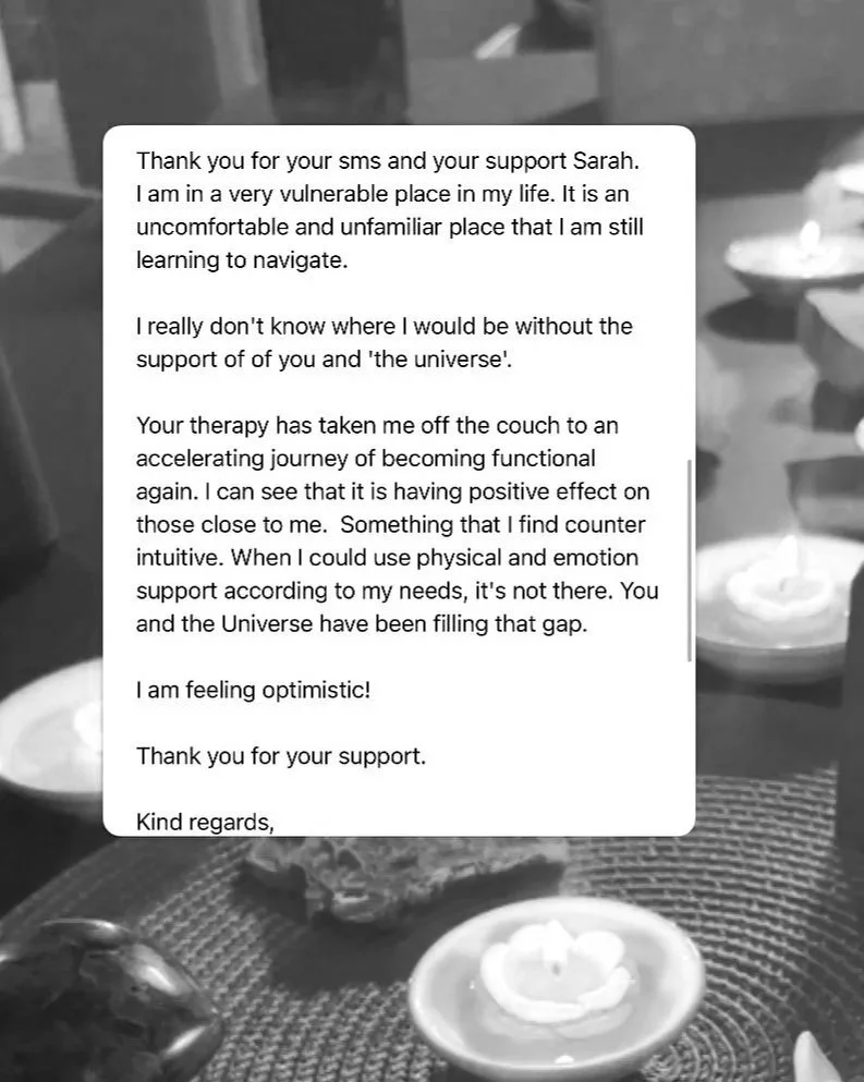 A letter of gratitude and support, placed on a table with lit candles and stones in the background, creating a calm and reflective atmosphere.