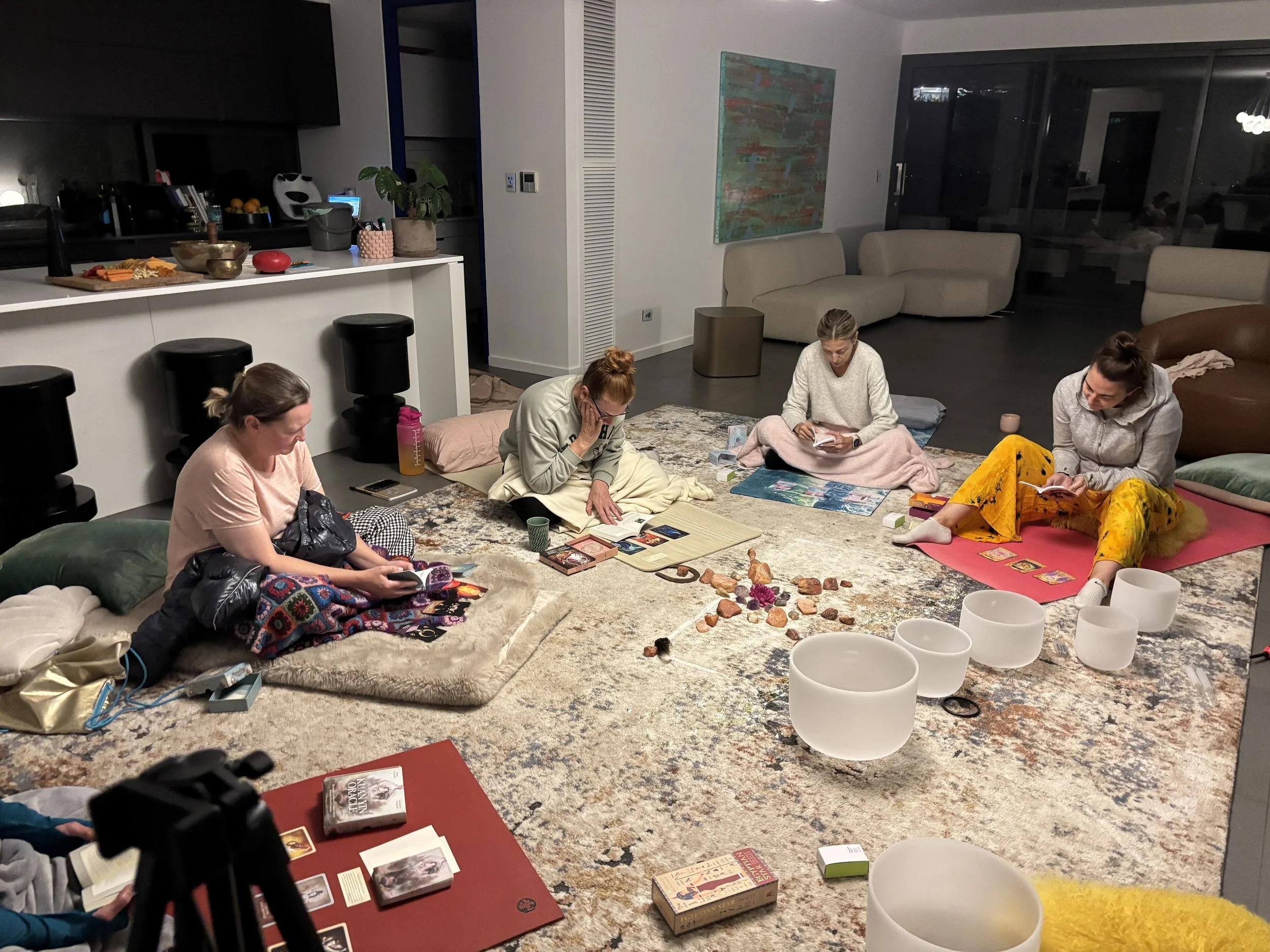 People sitting around on the floor playing board games and engaging in an activity in a living room with modern furniture and decor.