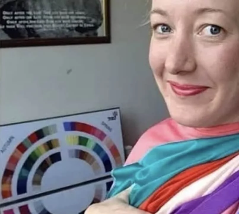 Person wearing colorful fabric swatches with a color chart in the background.