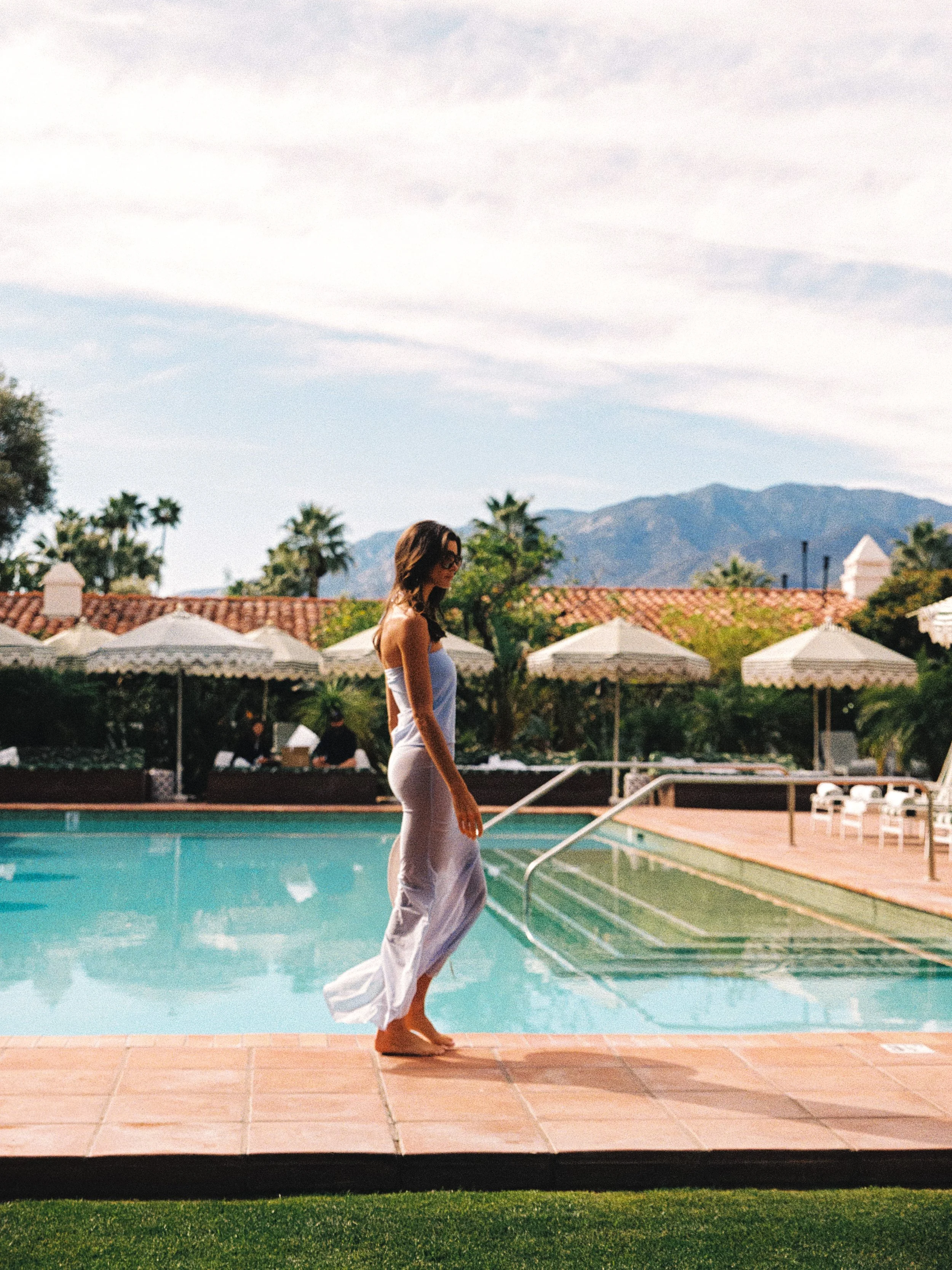 Club d'Antibes lilac strapless maxi dress worn poolside at a Spanish-style resort with scalloped umbrellas and mountain views, courtesy of Club d'Antibes, featured in the SABLE WEST Bella Hadid style edit 2026