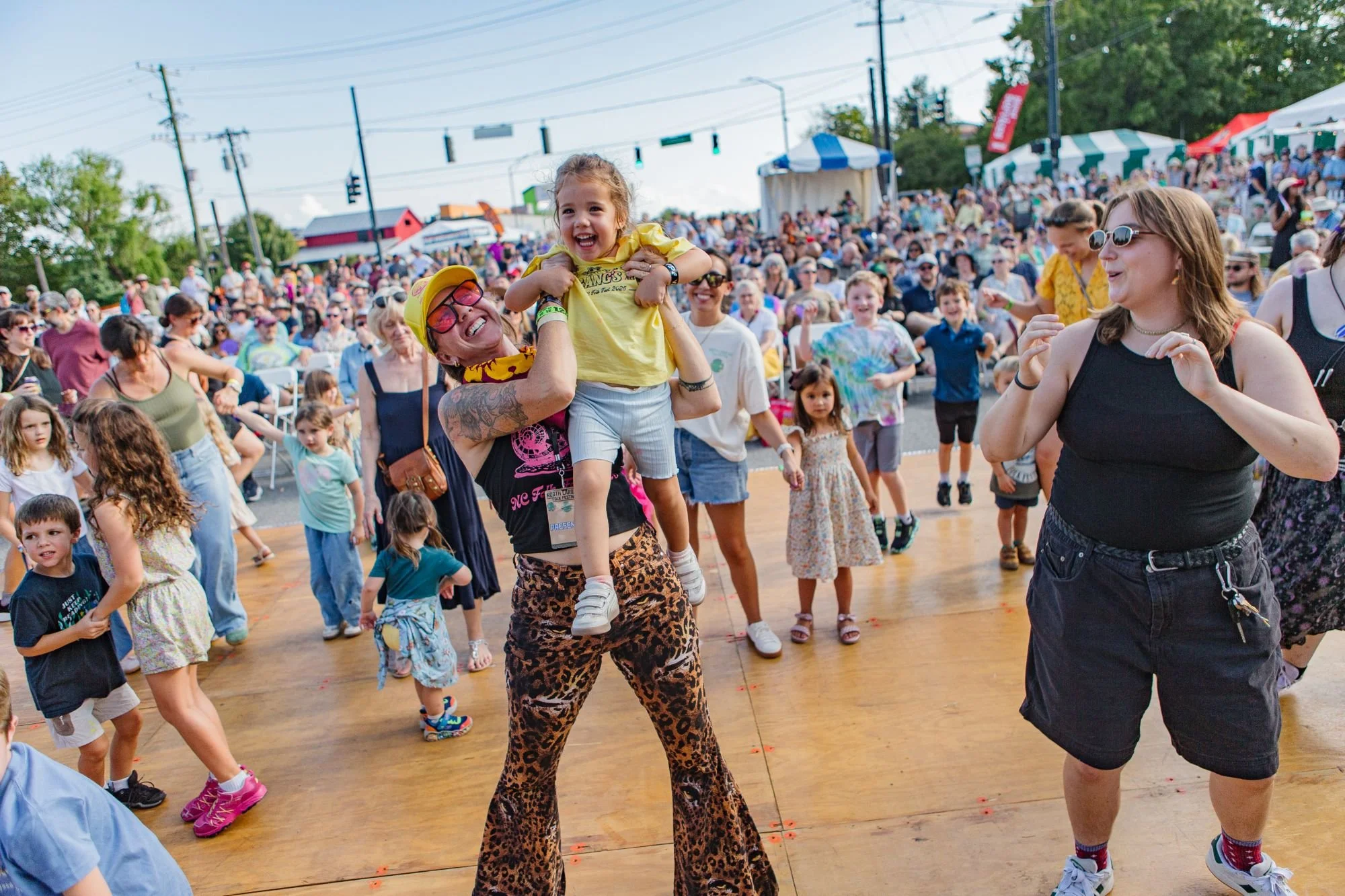 A mom and her child dancing at the NC Folk Festival