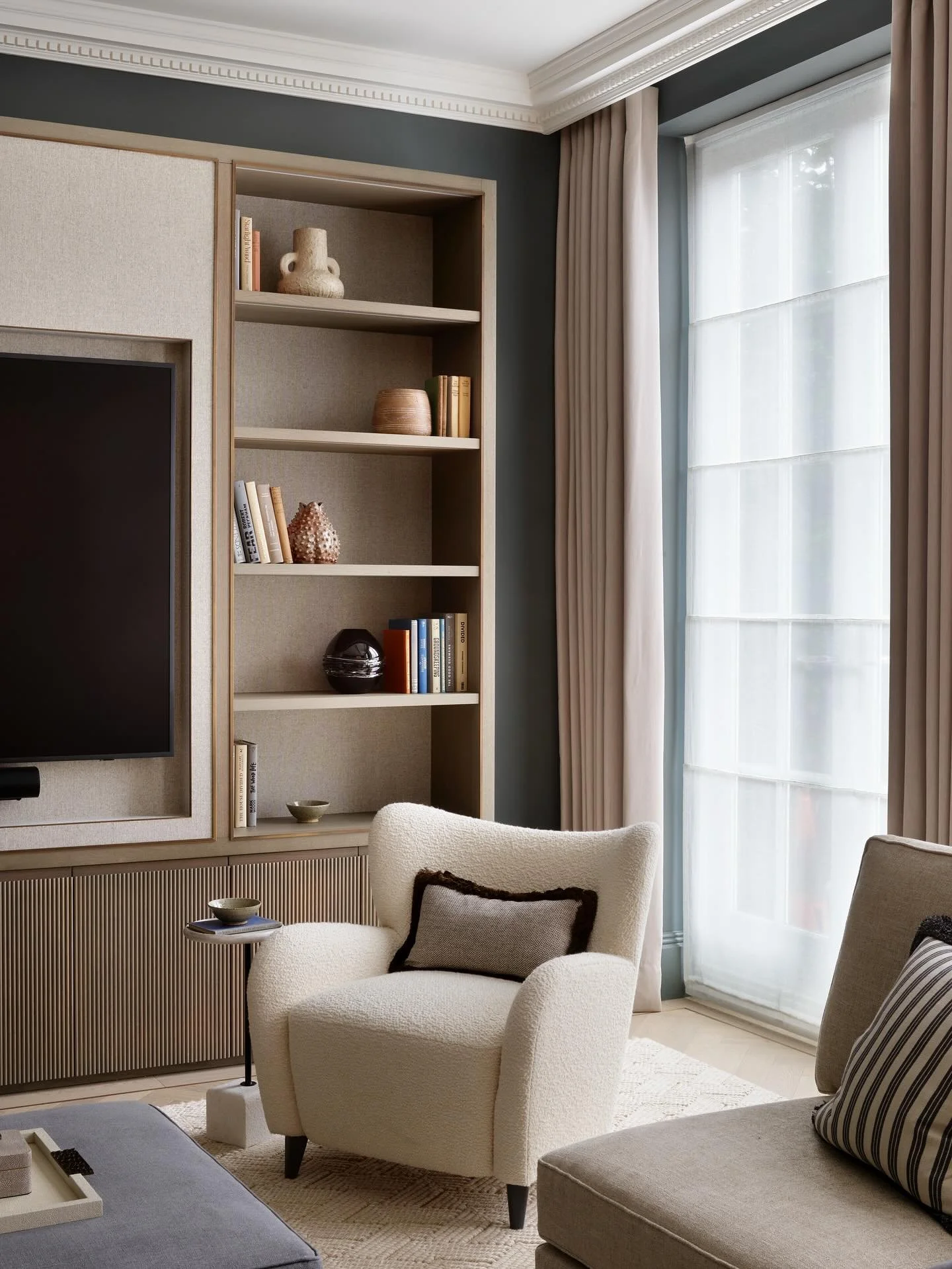 A cosy corner of the TV room in our Surrey project that we unveiled earlier this year. 

Our joinery team built the media wall incorporating a variety of curated materials to create layers, which add depth and achieve this effortlessly luxe feel to t
