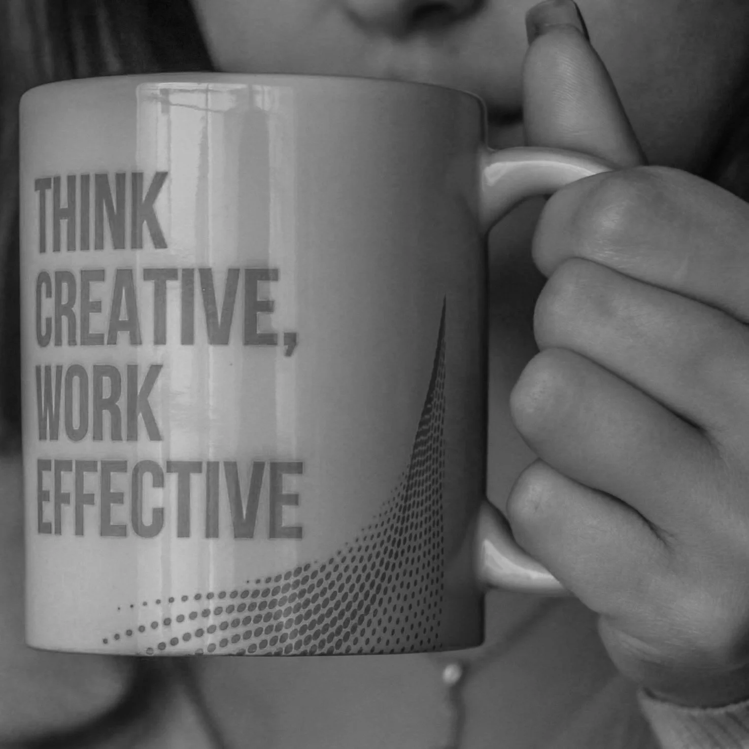 Person holding a coffee mug with the words "Think Creative, Work Effective" printed on it.