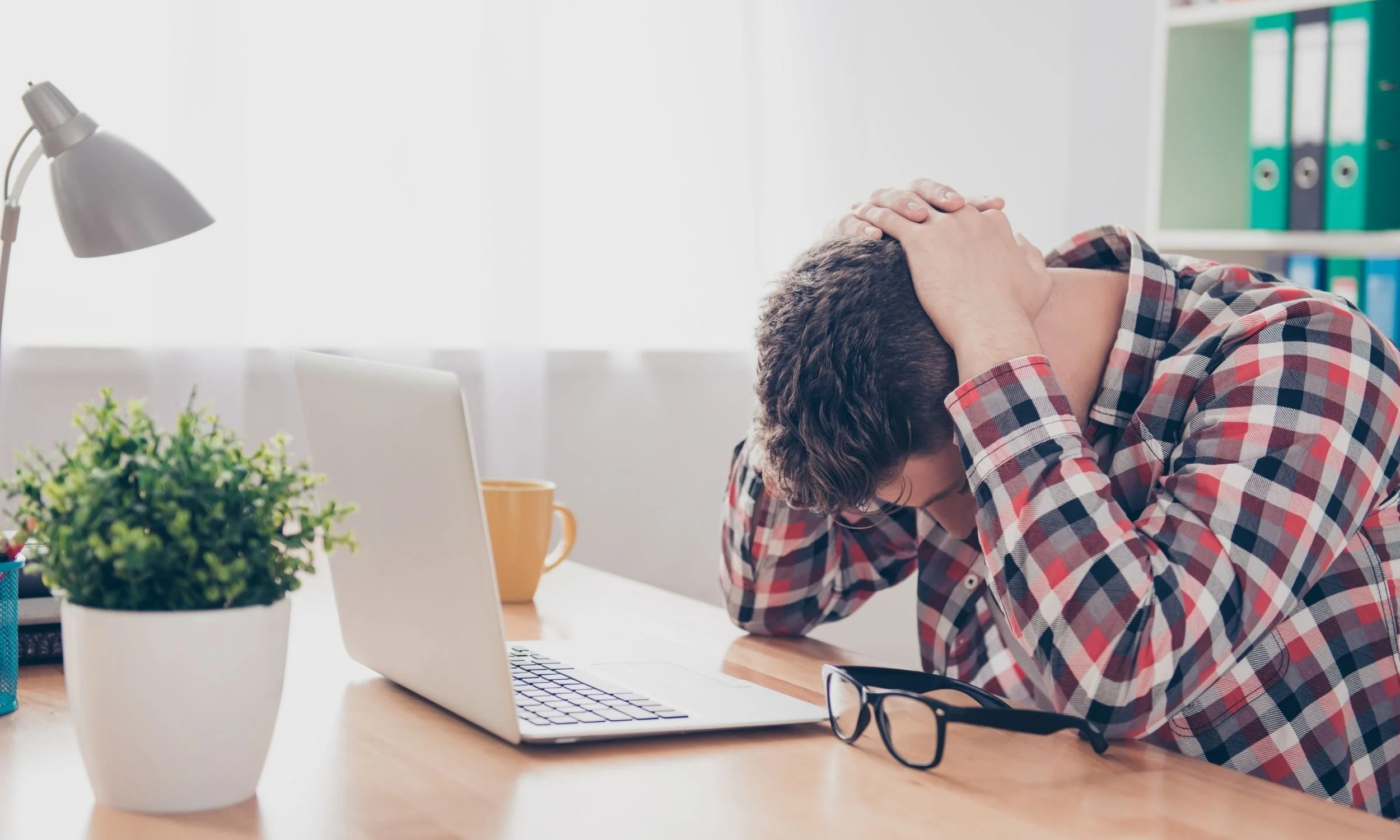 Stressed marketer at a laptop, representing ROAS issues caused by weak product feed management