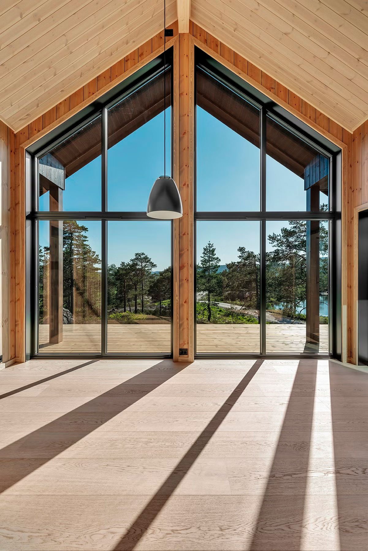 Store vindusflater som trekker naturen inn i stue.