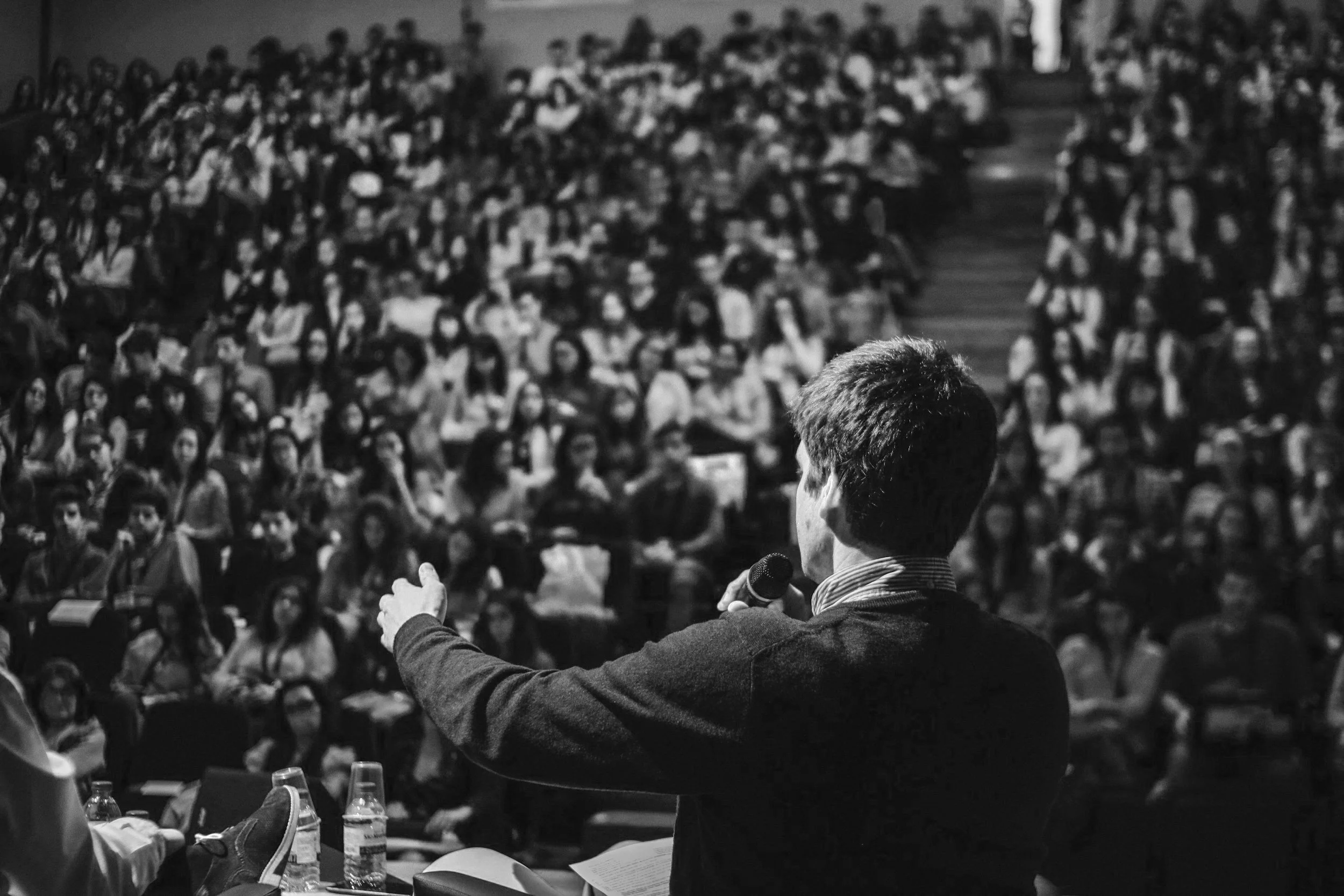 Speaker addressing large audience in auditorium