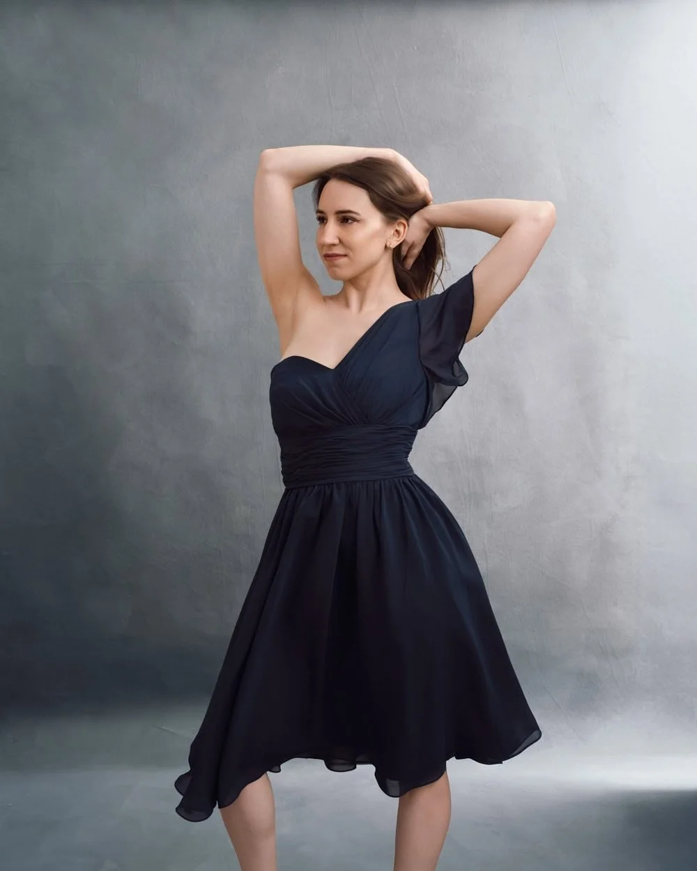 Portrait élégant en studio d'une femme en robe fluide