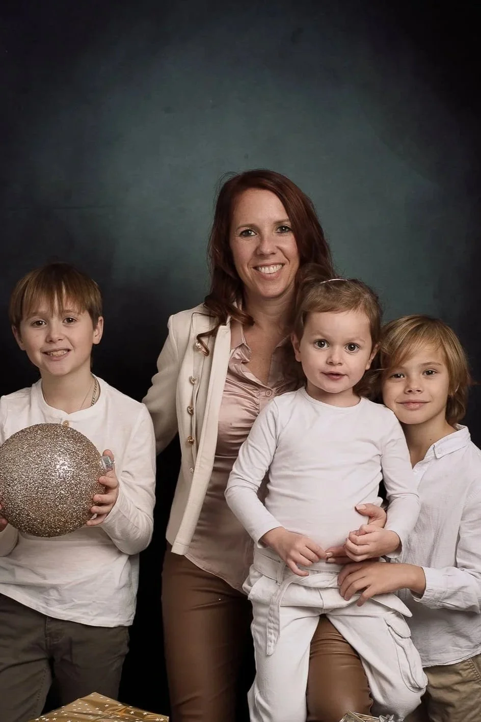 Séance photo famille en studio à Strasbourg : maman entourée de ses trois enfants sur fond peint.