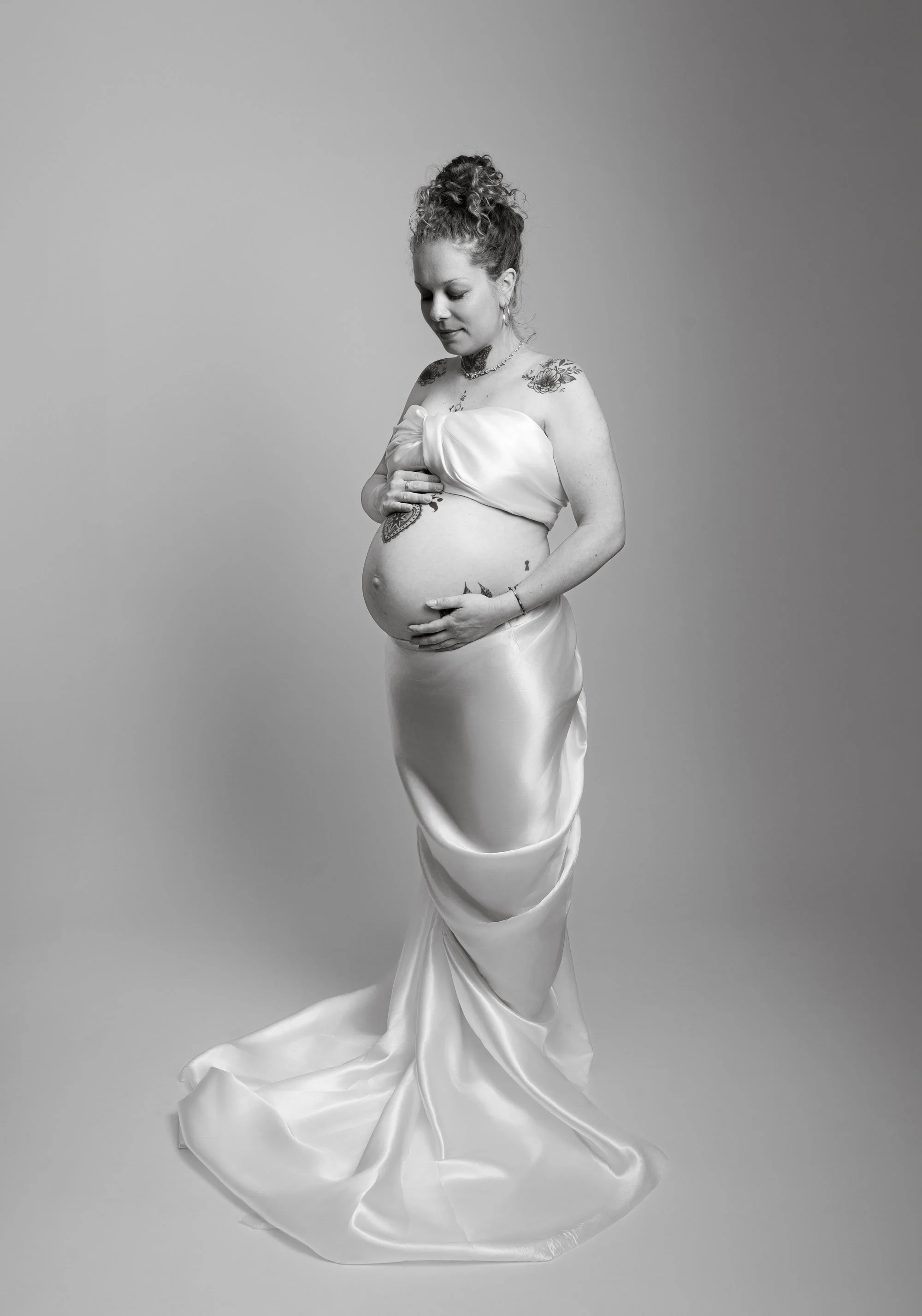 Photographe grossesse à Strasbourg : future maman dans un long drapé blanc photographiée en noir et blanc