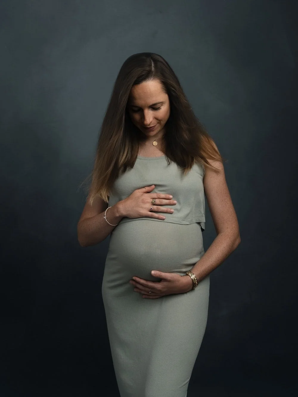 Photographe grossesse Strasbourg femme enceinte robe verte regard doux sur le ventre