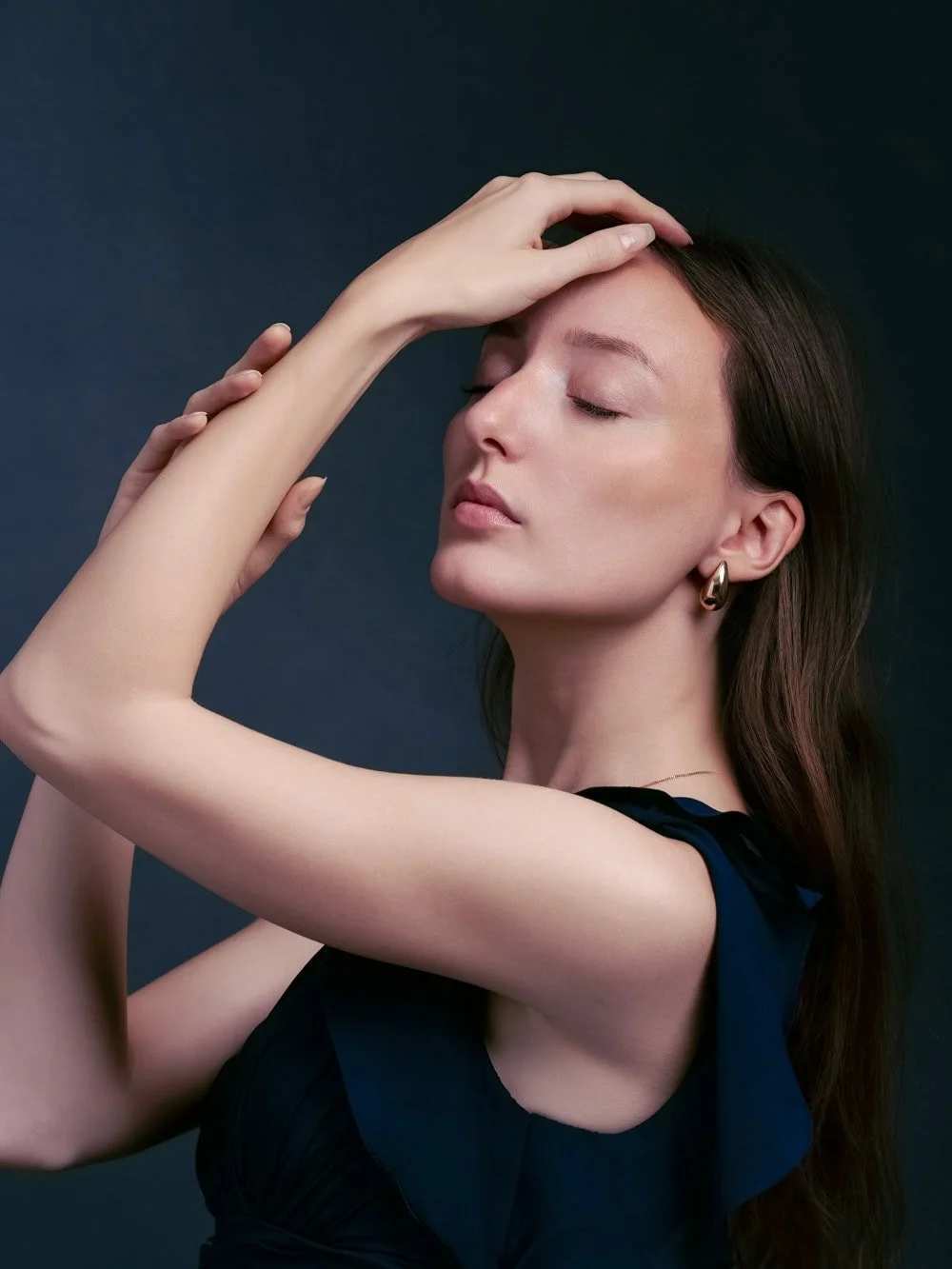 Portrait Fine Art d'une femme les yeux fermés, lumière douce et fond sombre.