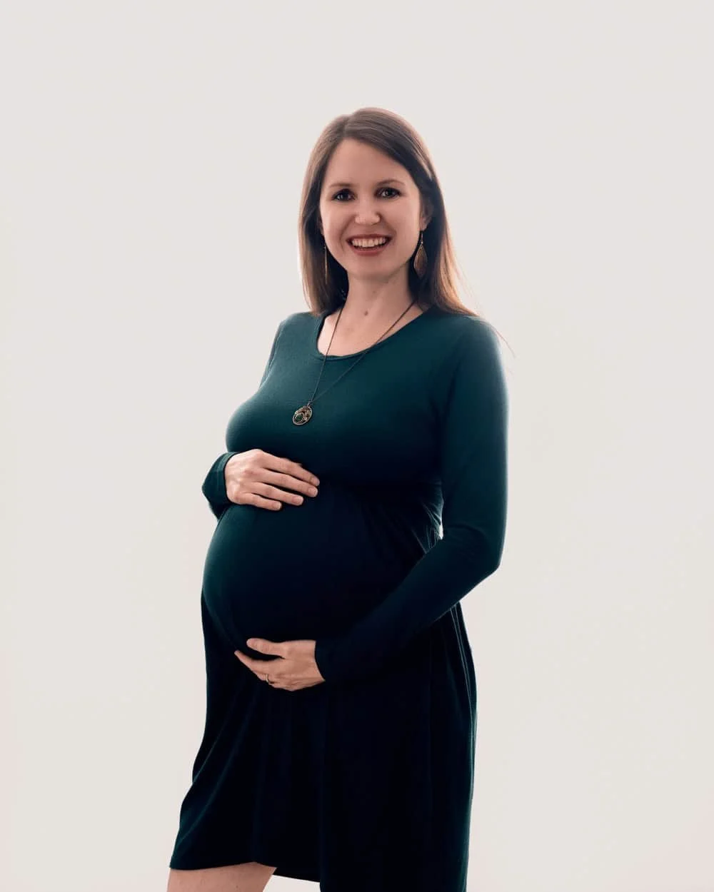 Future maman en robe verte pendant une séance photo grossesse à Strasbourg