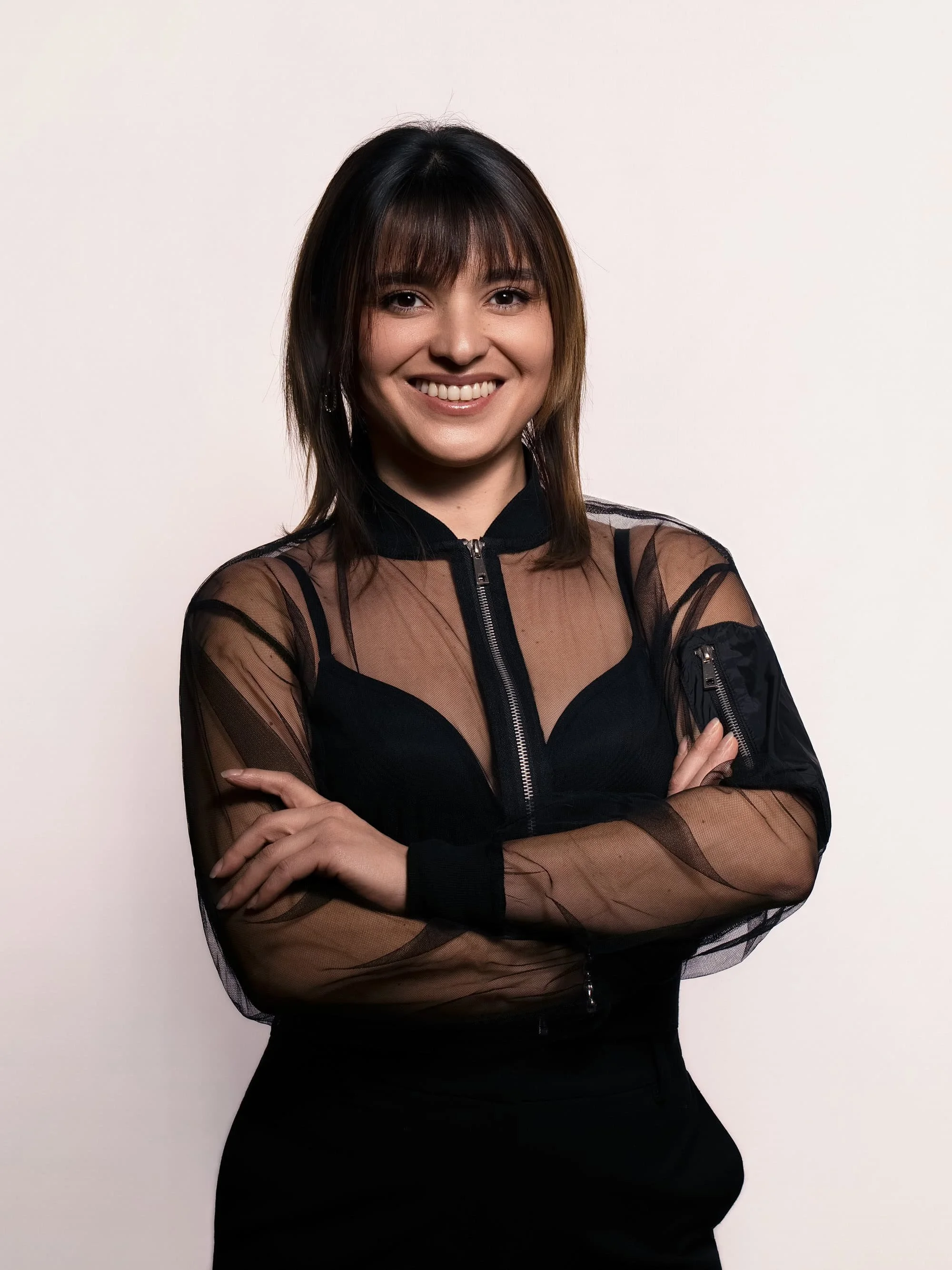Portrait souriant d’une femme en tenue noire sur fond clair
