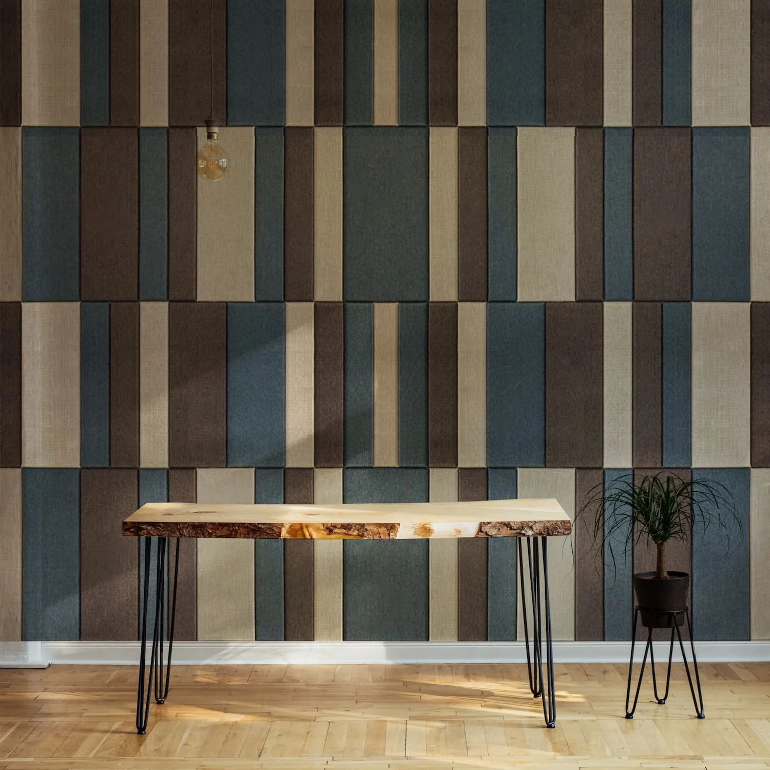 Moderan enterijer sa drvenim stolom i sobnom biljkom ispred zida sa geometrijskim dekorativnim akustičnim filc panelima, koji kombinuju estetiku i funkcionalnost.