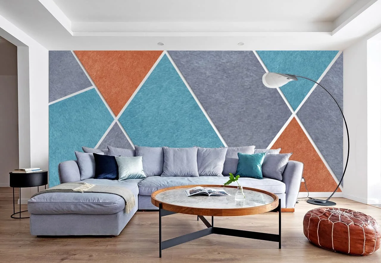 Moderan dnevni boravak sa ugaonom garniturom, drvenim stolom, geometrijskim akcentnim zidom od akustičnih filc panela, podnom lampom i dekorativnim detaljima. Savršena kombinacija udobnosti i savremenog dizajna.