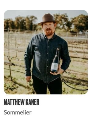 Man holding wine bottle in vineyard setting