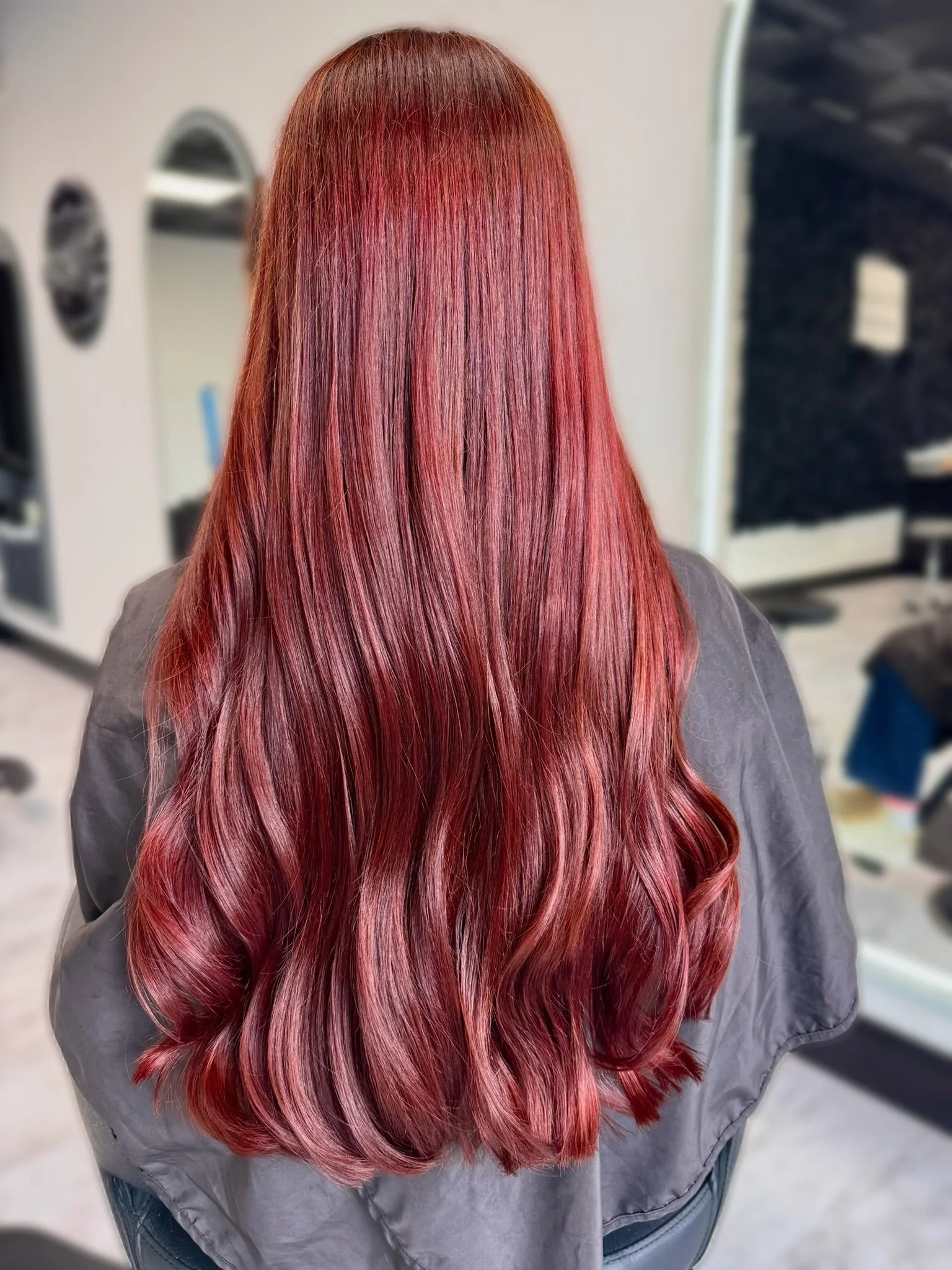Rich burgundy red hair color with deep dimensional tones and a glossy finish at Altair Salon in Palm City, FL. Customized red hair color for vibrant, long-lasting dimension.