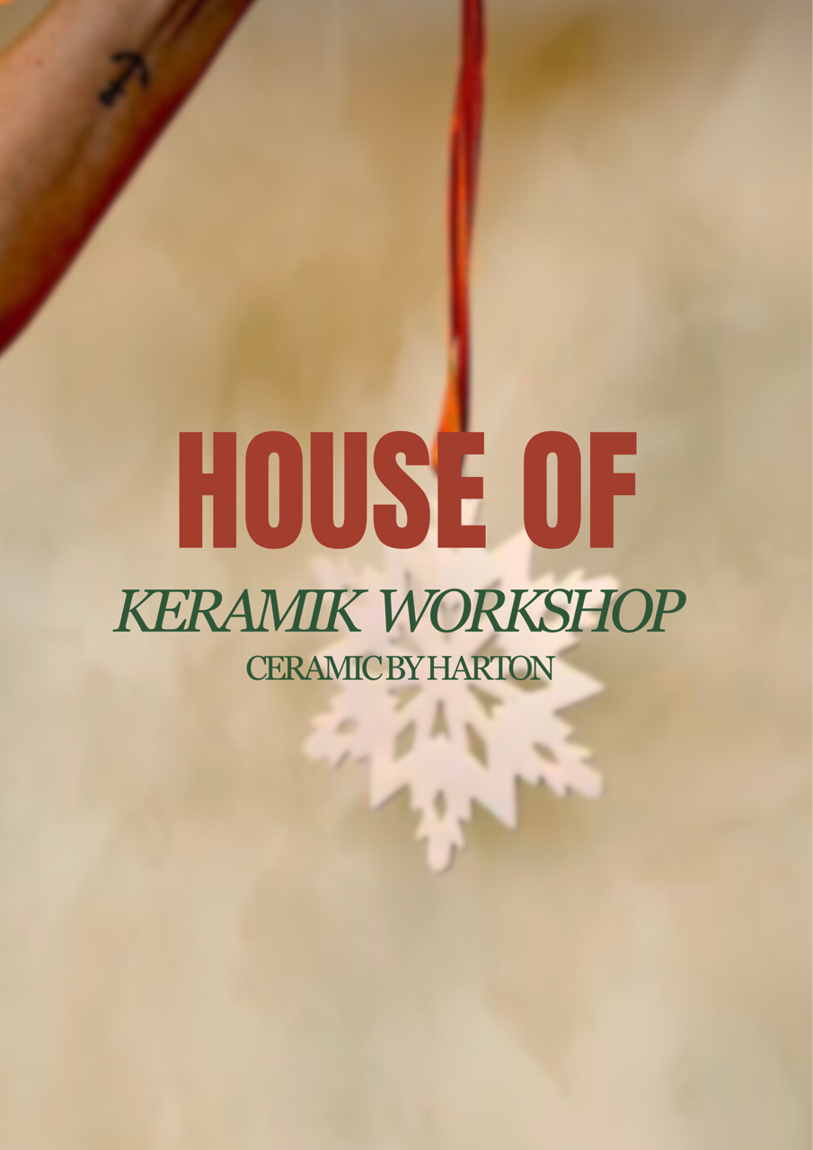 Three pink Christmas ornaments decorated with gold accents, placed alongside pine branches and a small bell, with blurred background lights.