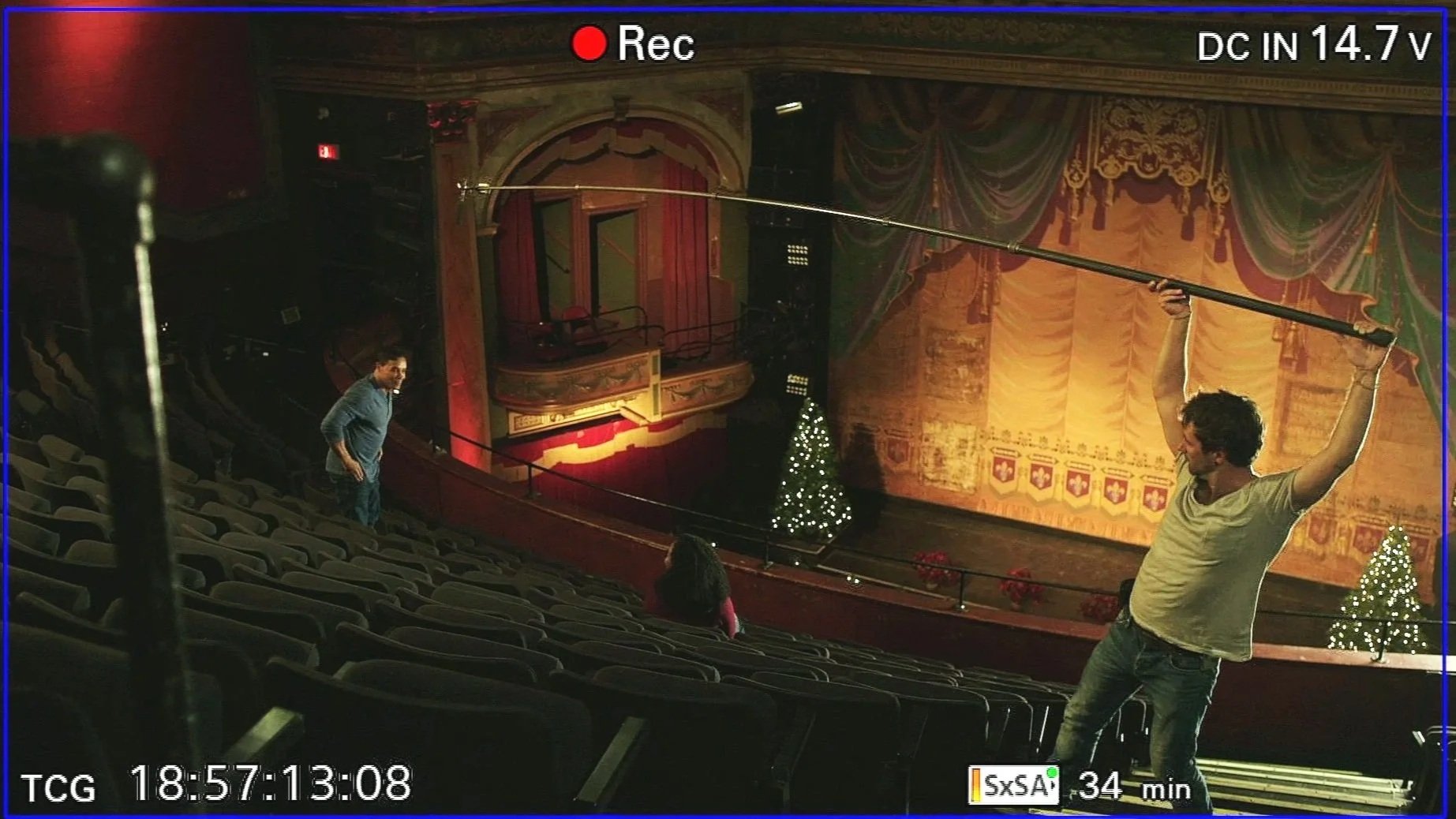 L'intérieur d'une salle du théâtre avec des décorations de Noël, un arbre de Noël et des rideaux dorés, en train de préparer une scène pour une représentation.