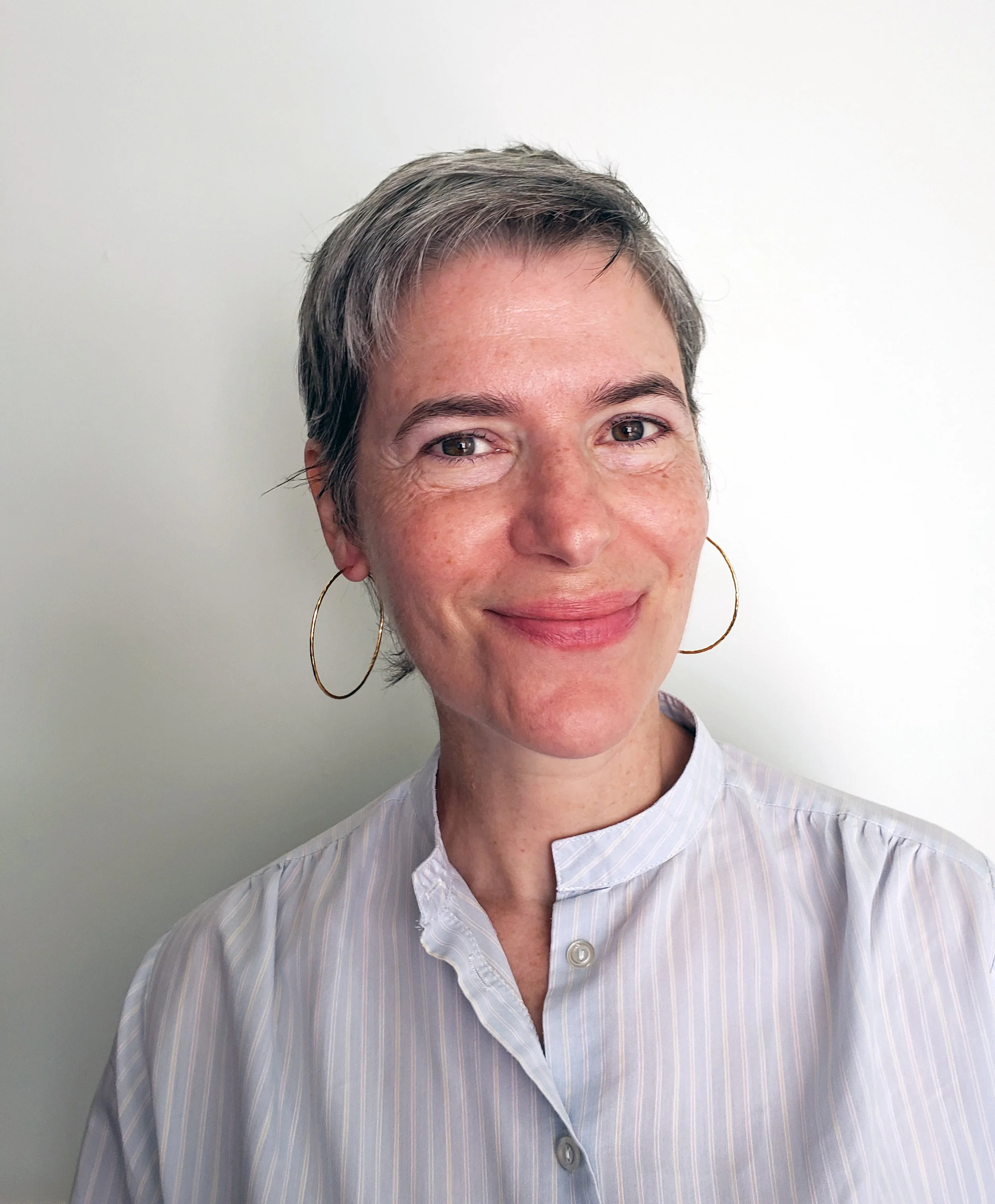 Elizabeth Pace website clarity and messaging consultant wearing a blue, striped shirt.