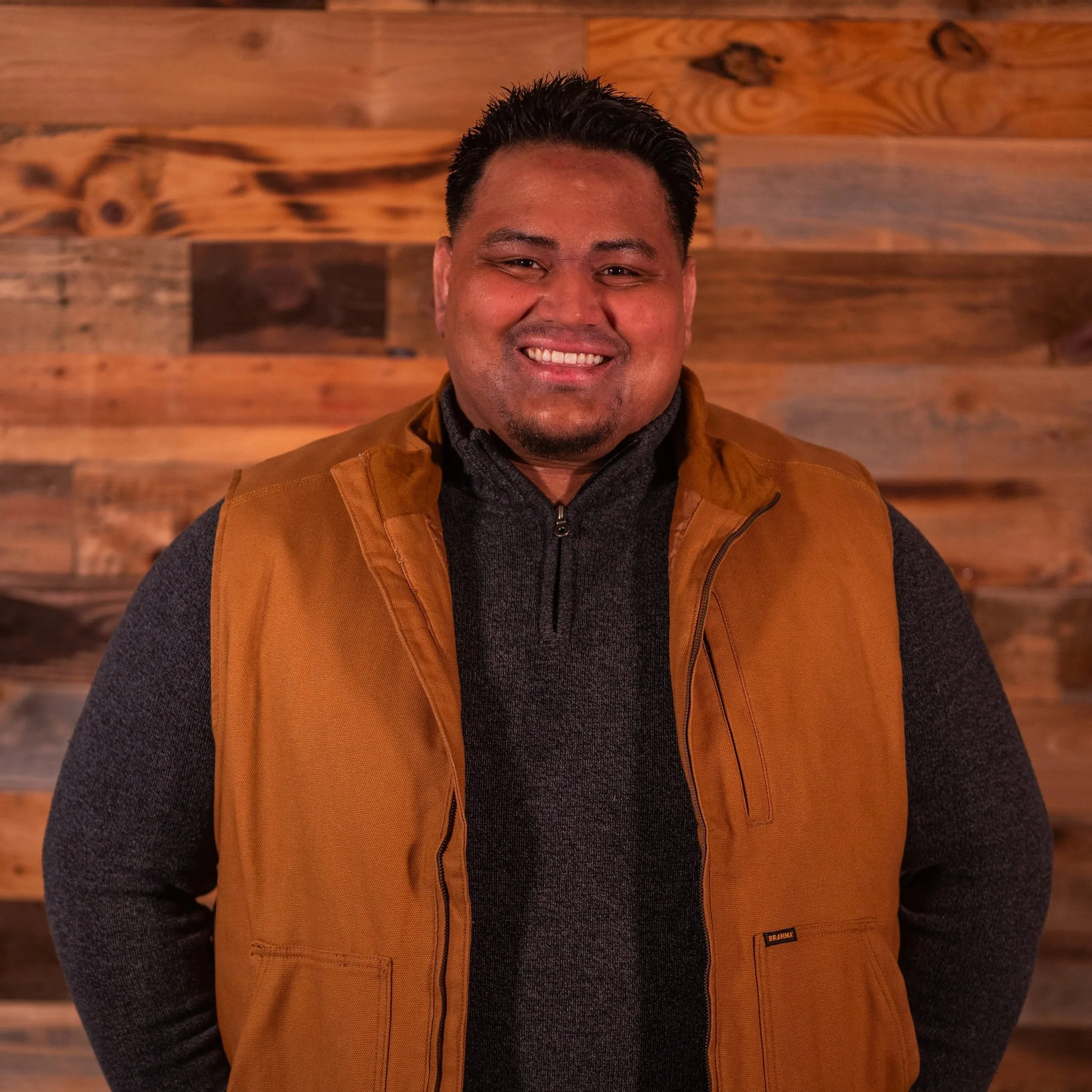 Smiling person wearing a floral patterned shirt.