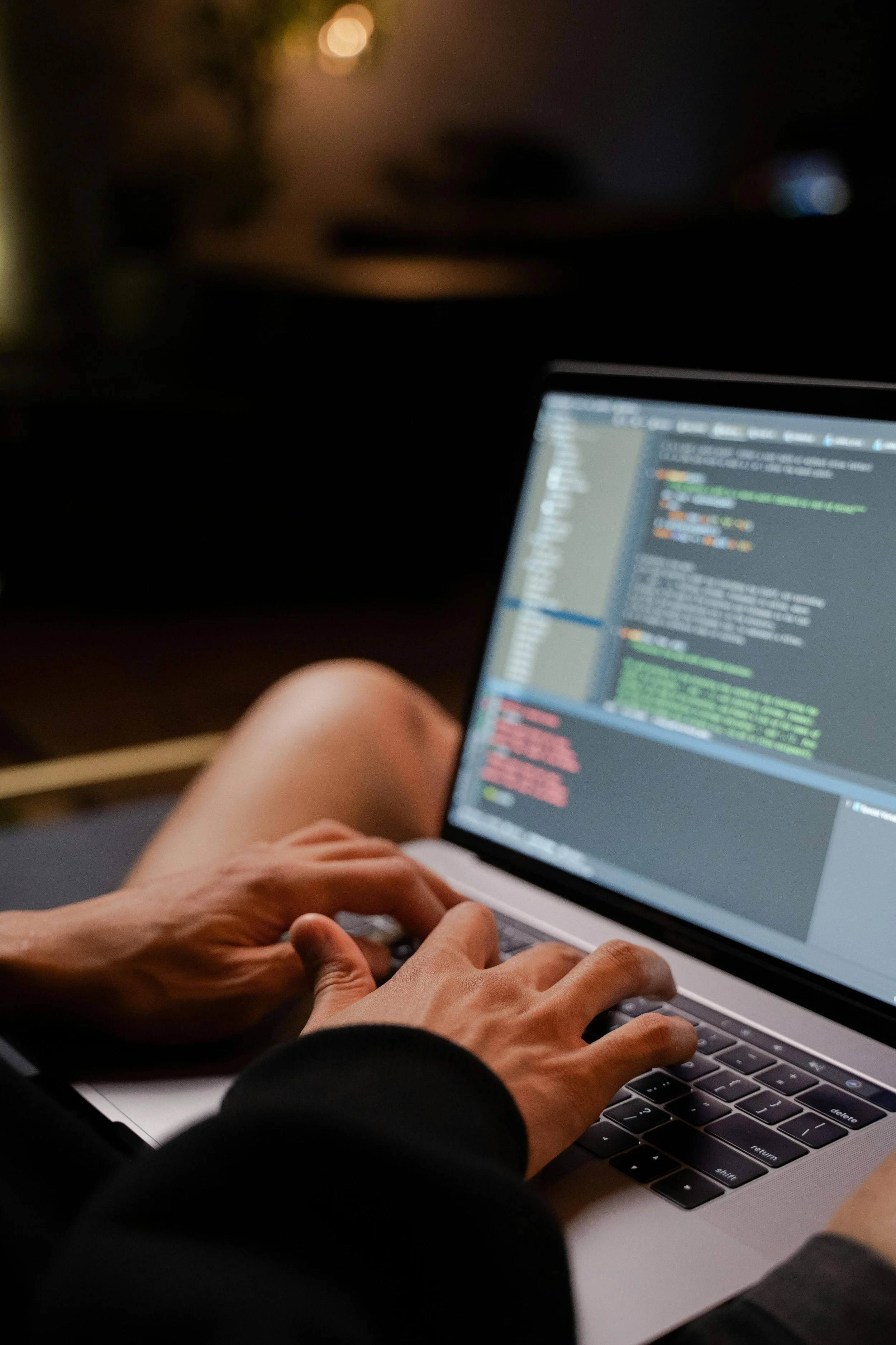 Person typing on a laptop with code on the screen