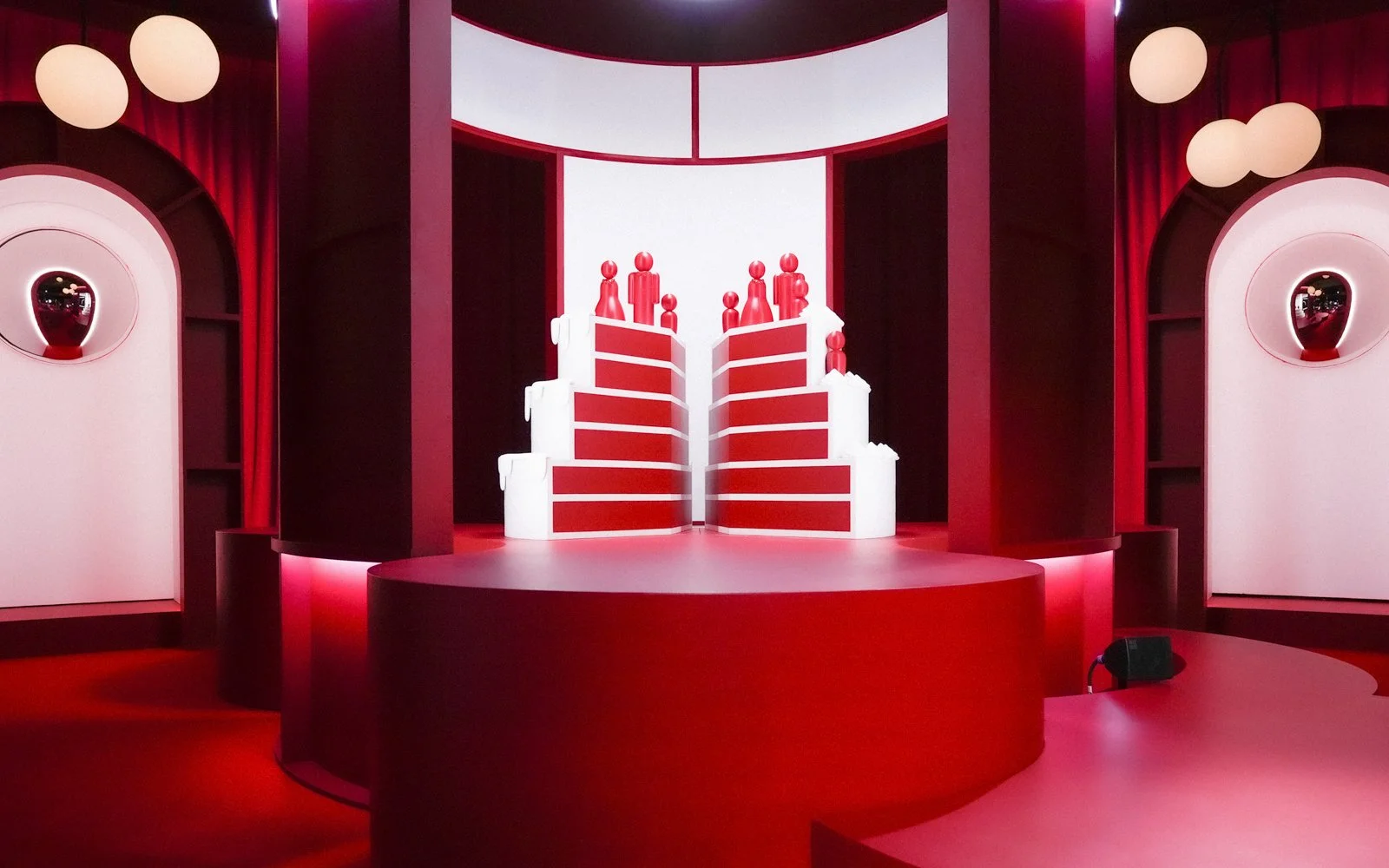 Custom TV studio scenography with wedding cake-shaped backdrop anchoring presenter position